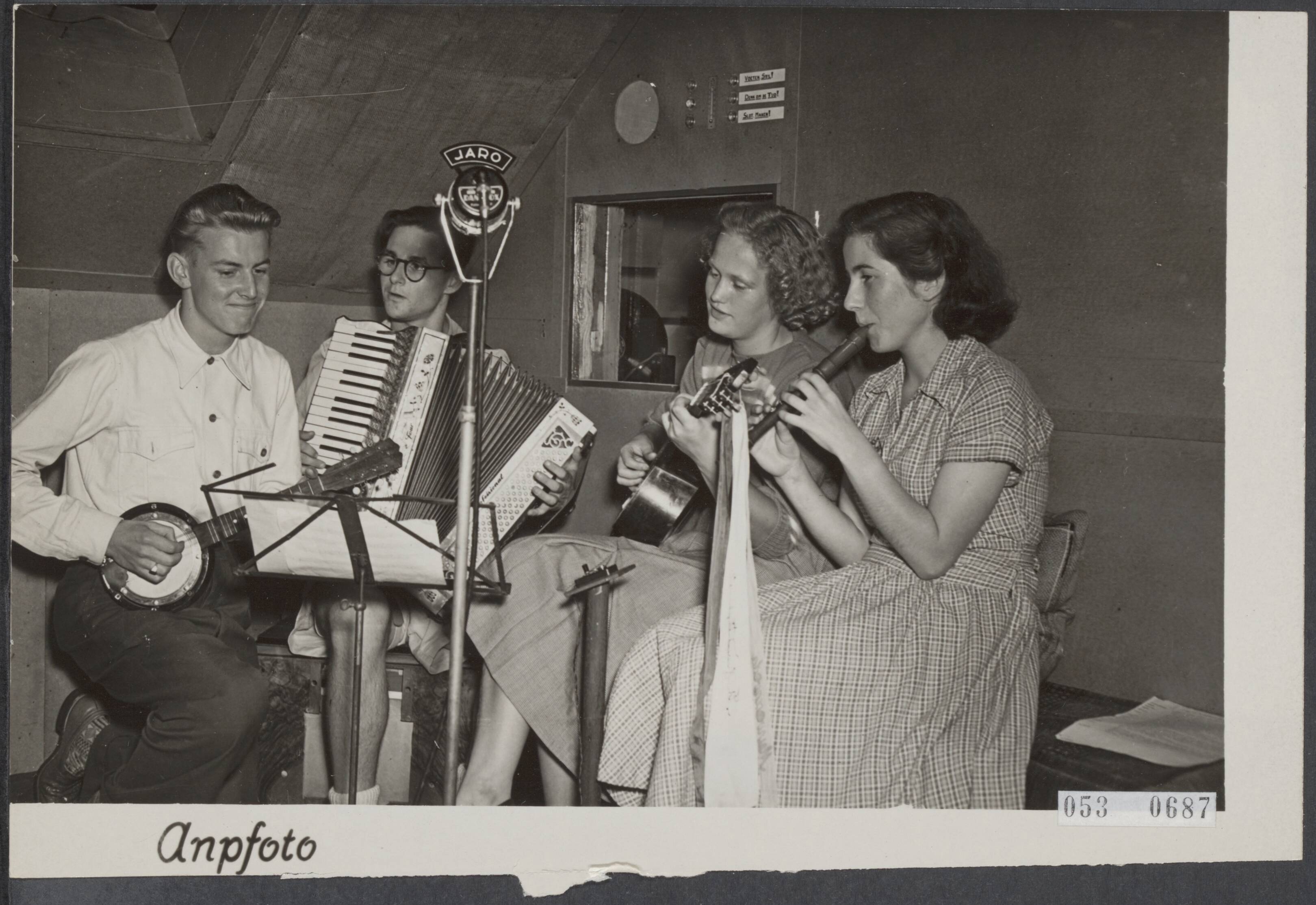 Fotocollectie Elsevier Binnenland — Jongelui uit Haarlem en omgeving hebben het plan opgevat om d.m.v. een eigen omroep "JARO" genaamd, radioprogramma's uit te zenden. Uit eigen middelen bouwden zij een zendinstallatie, compleet met studio etc. , welke is ondergebracht op de zolderkamers van een perceel Nassaustraat 7 te Haarlem. Voor persvertegenwoordigers vond een uitzending plaats, die, aangezien de ministeriële toestemming voor een zendvergunning nog niet is verkregen, binnenshuis via een draadverbinding naar een kamer in het benedenhuis moest geschieden — Foto: ANP / RVD of rechtenvrij. Licentie: Set B: Rechtenvrij / Publiek Domein. Bron: Nationaal Archief. http://hdl.handle.net/10648/ae07007e-d0b4-102d-bcf8-003048976d84
