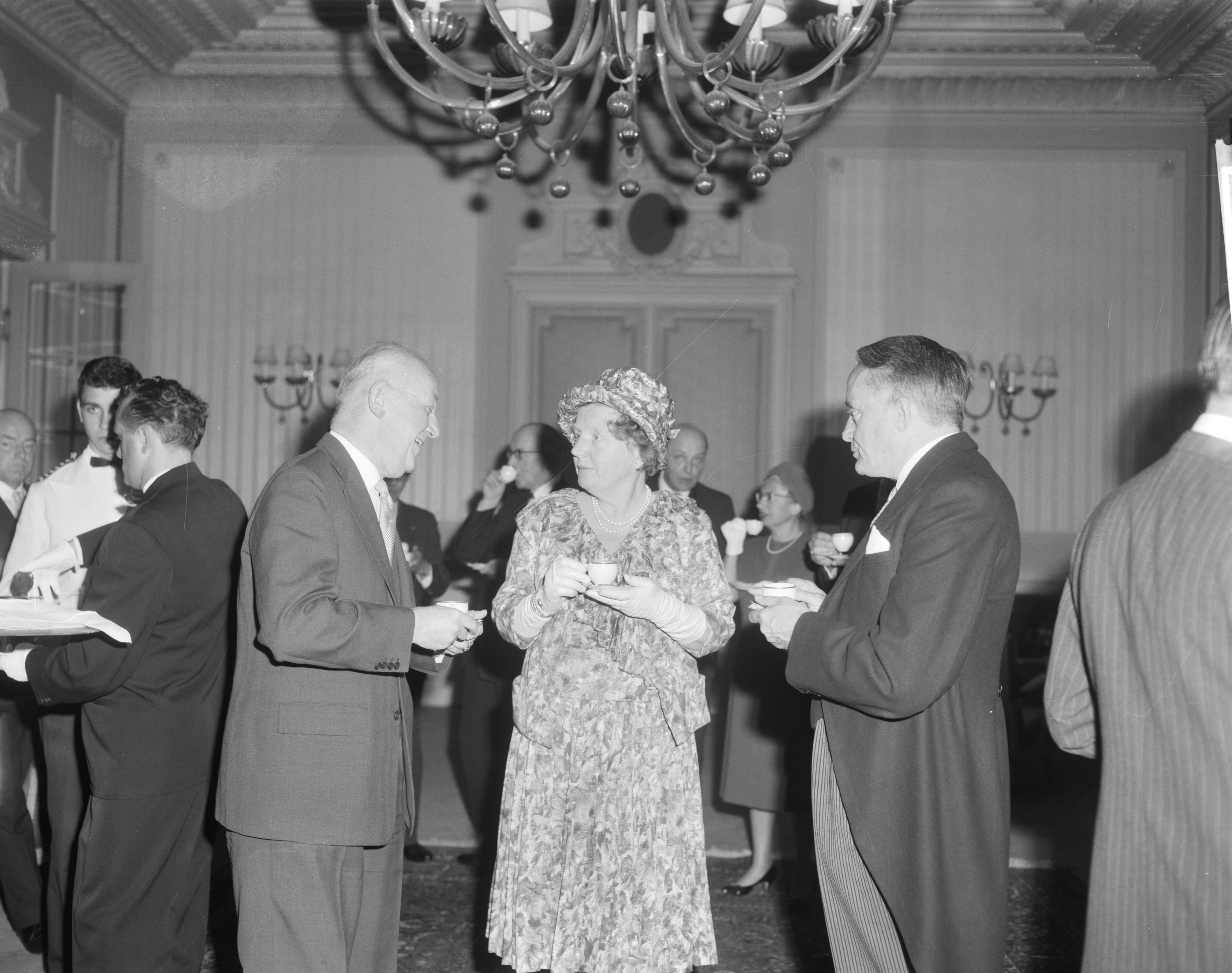 Fotocollectie Anefo — Koningin Juliana is aanwezig bij de viering van het 50-jarig bestaan van de Vereniging van Nederlandse Gemeenten in de Kurzaal te Scheveningen. Links van de koningin de burgemeester van Den Haag, H.A.M.T. Kolfschoten, en rechts de Commissaris der Koningin in Zuid-Holland, mr. J. Klaasesz — Foto: Bilsen, Joop van / Anefo. Licentie: Set B: Rechtenvrij / Publiek Domein. Bron: Nationaal Archief. http://hdl.handle.net/10648/aa0b7ee6-d0b4-102d-bcf8-003048976d84