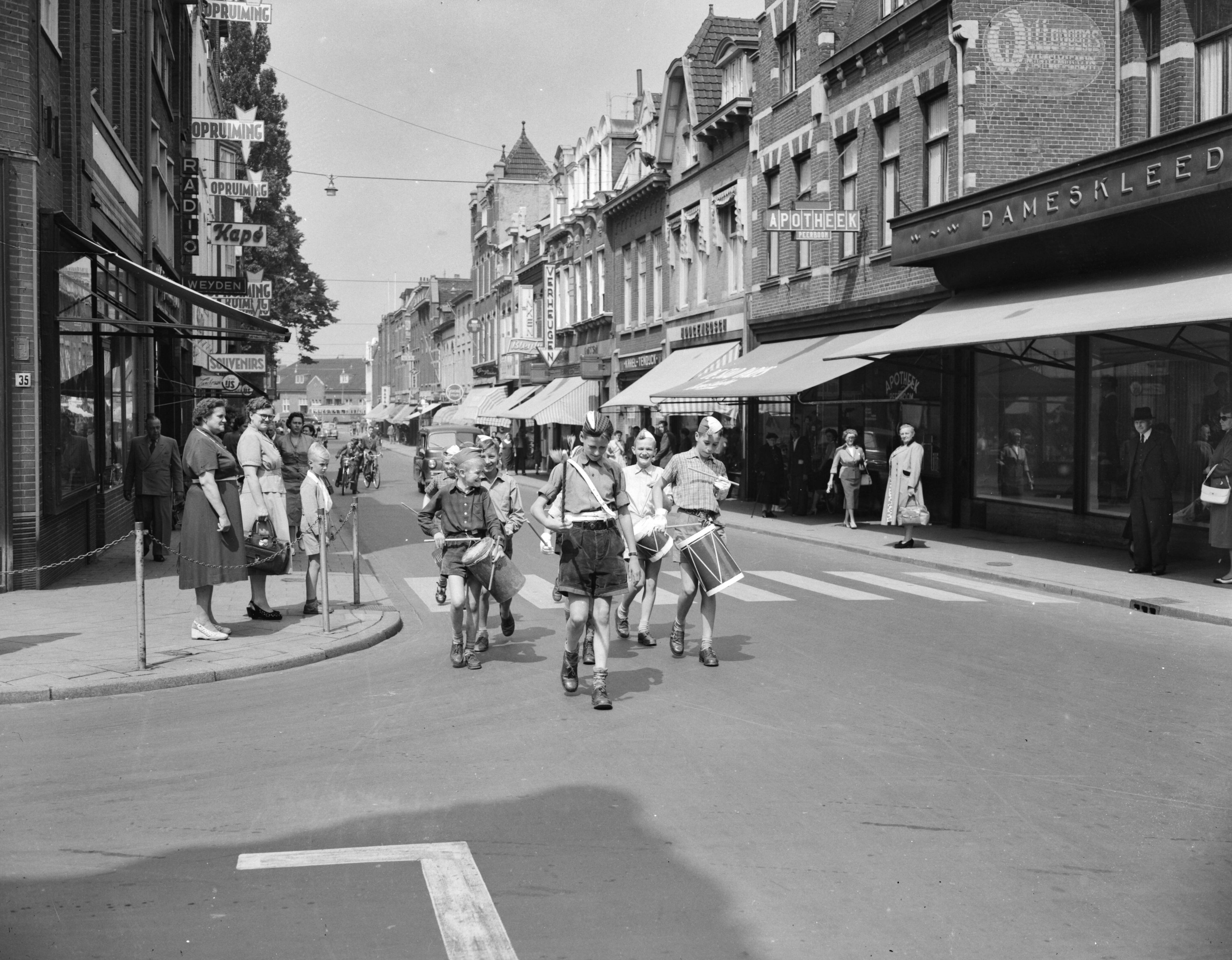 Fotocollectie Anefo — De jeugd van Heerlen bereidt zich voor op het Spectakel-concours dat op 28 augustus gehouden wordt. Onder leiding van een tambour-maitre en met veel lawaai oefent een groep deelnemers in de straten van Heerlen — Foto: Pot, Harry / Anefo. Licentie: Set B: Rechtenvrij / Publiek Domein. Bron: Nationaal Archief. http://hdl.handle.net/10648/a93996ec-d0b4-102d-bcf8-003048976d84