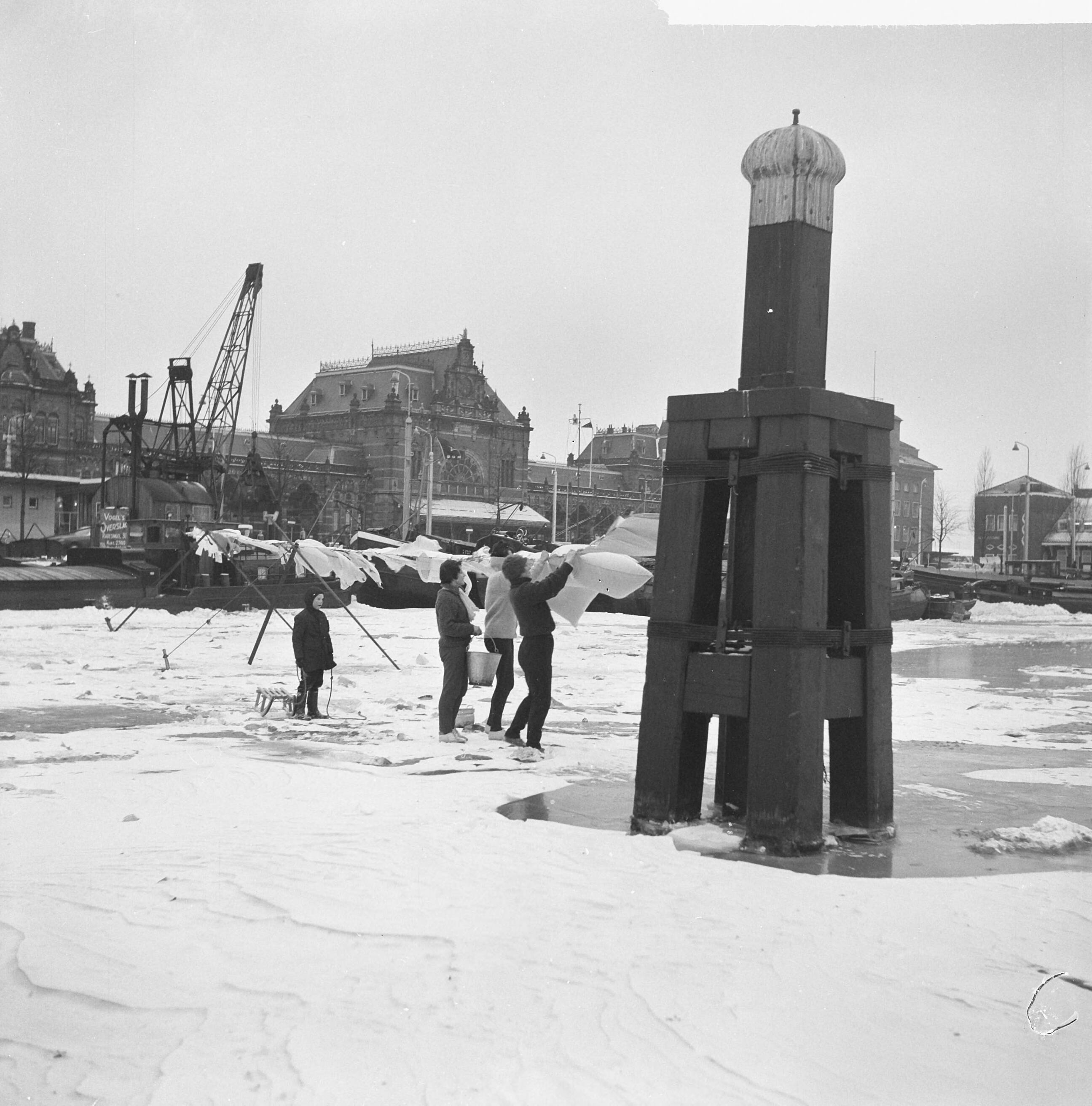 Fotocollectie Anefo — De was hangt op het dichtgevroren Verbindingskanaal te Groningen — Foto: Nijs, Jac. de / Anefo. Licentie: Set B: Rechtenvrij / Publiek Domein. Bron: Nationaal Archief. http://hdl.handle.net/10648/aa24d6f2-d0b4-102d-bcf8-003048976d84