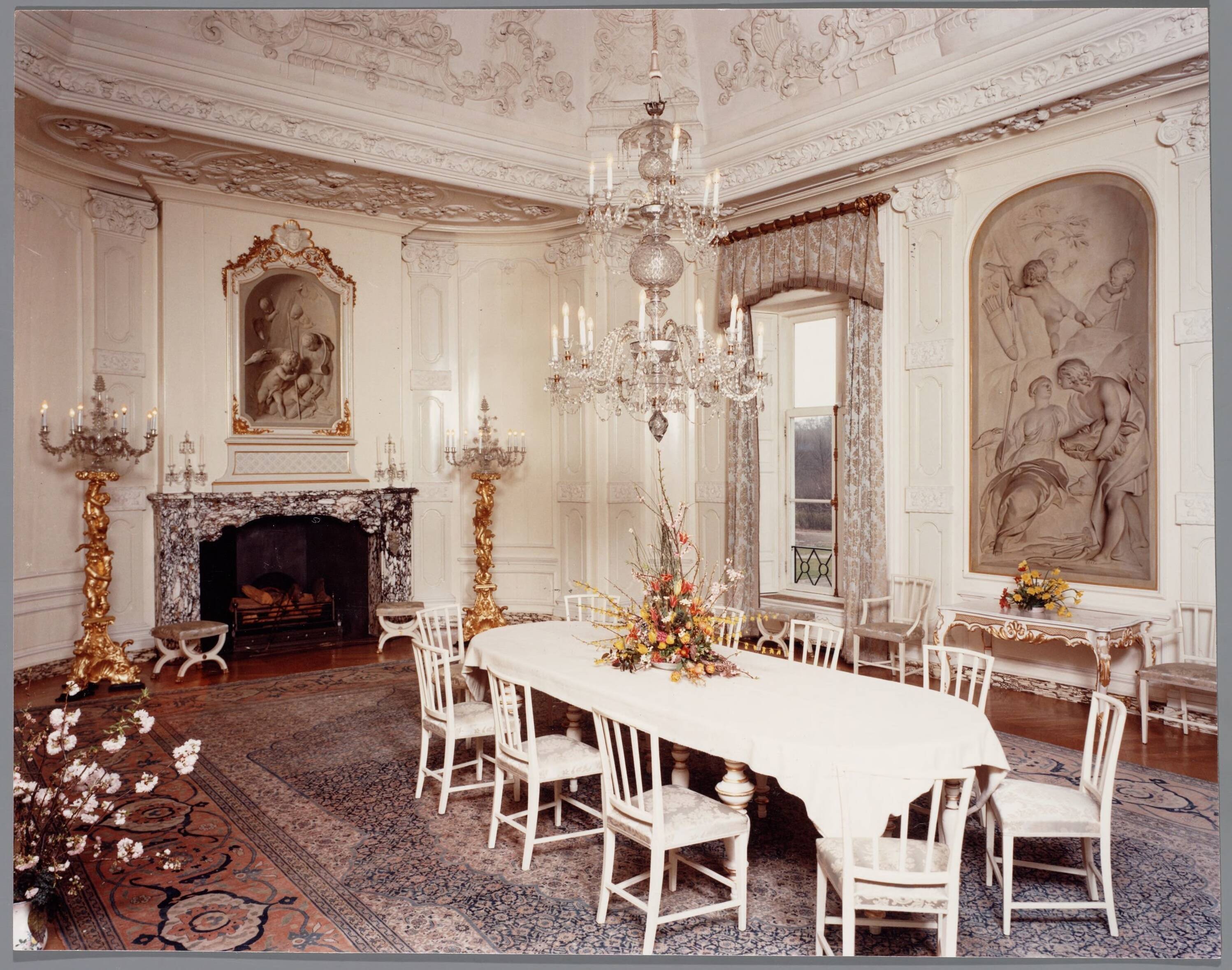 Paleis Huis ten Bosch te Den Haag — Overzicht Witte Eetzaal, met de beroemde "witjes" van Jacob de Witt. Deze "witjes" zijn schilderijen, die erg op beeldhouwwerk lijken — Foto: Hofmeester, Bart / RVD. Licentie: Set B: Rechtenvrij / Publiek Domein. Bron: Nationaal Archief. http://hdl.handle.net/10648/afa8f27a-d0b4-102d-bcf8-003048976d84