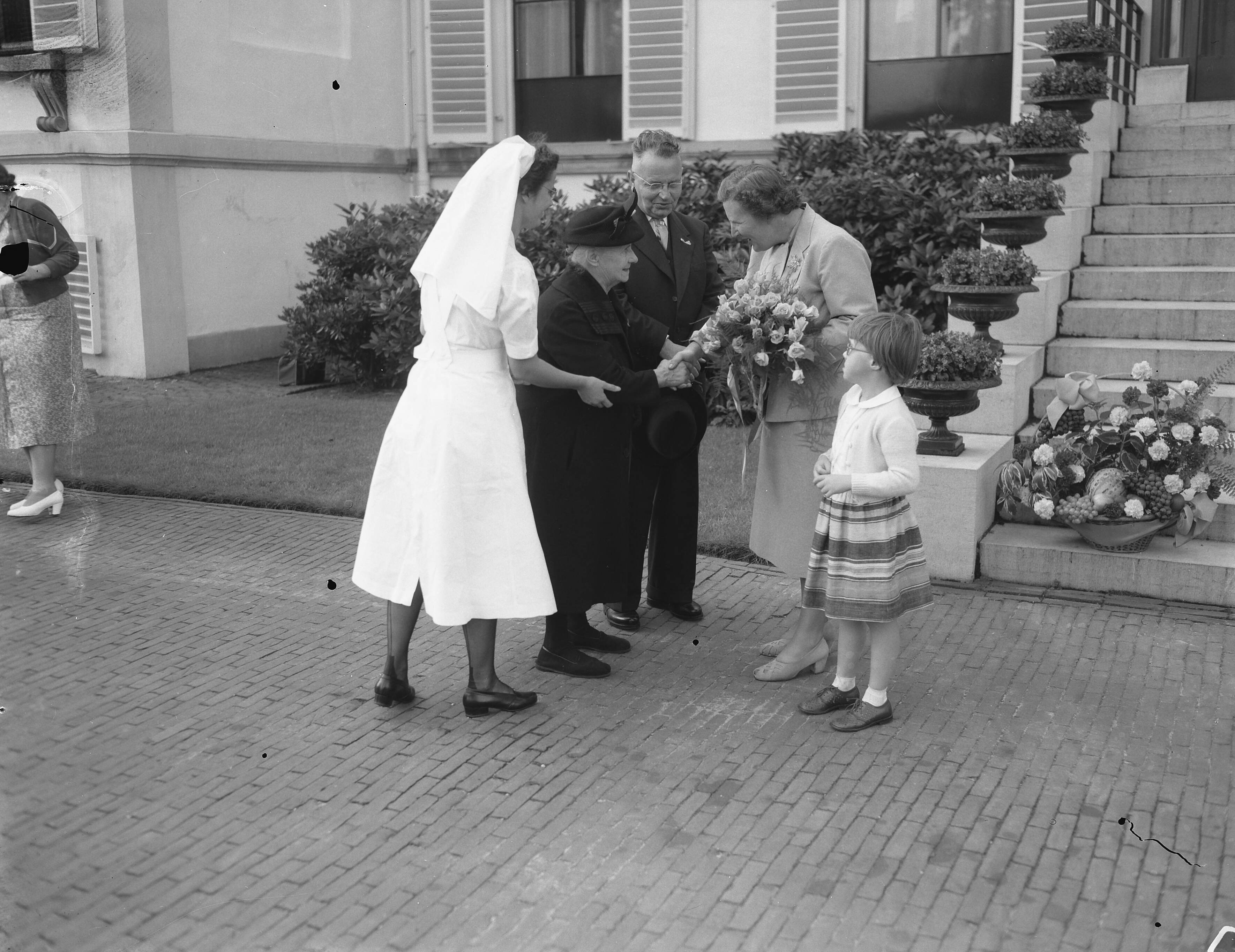 Fotocollectie Anefo — Koningin Juliana ontvangt delegaties Nederlandse bejaarden op paleis Soestdijk. De 89-jarige mevr. de wed. J. van Eymeren— Zijdemans uit Rotterdam en haar geleidster, zuster G. M. van Blooys, werden begroet door koningin Juliana en prinses Marijke — Foto: Noske, J.D. / Anefo. Licentie: Set B: Rechtenvrij / Publiek Domein. Bron: Nationaal Archief. http://hdl.handle.net/10648/a9298680-d0b4-102d-bcf8-003048976d84