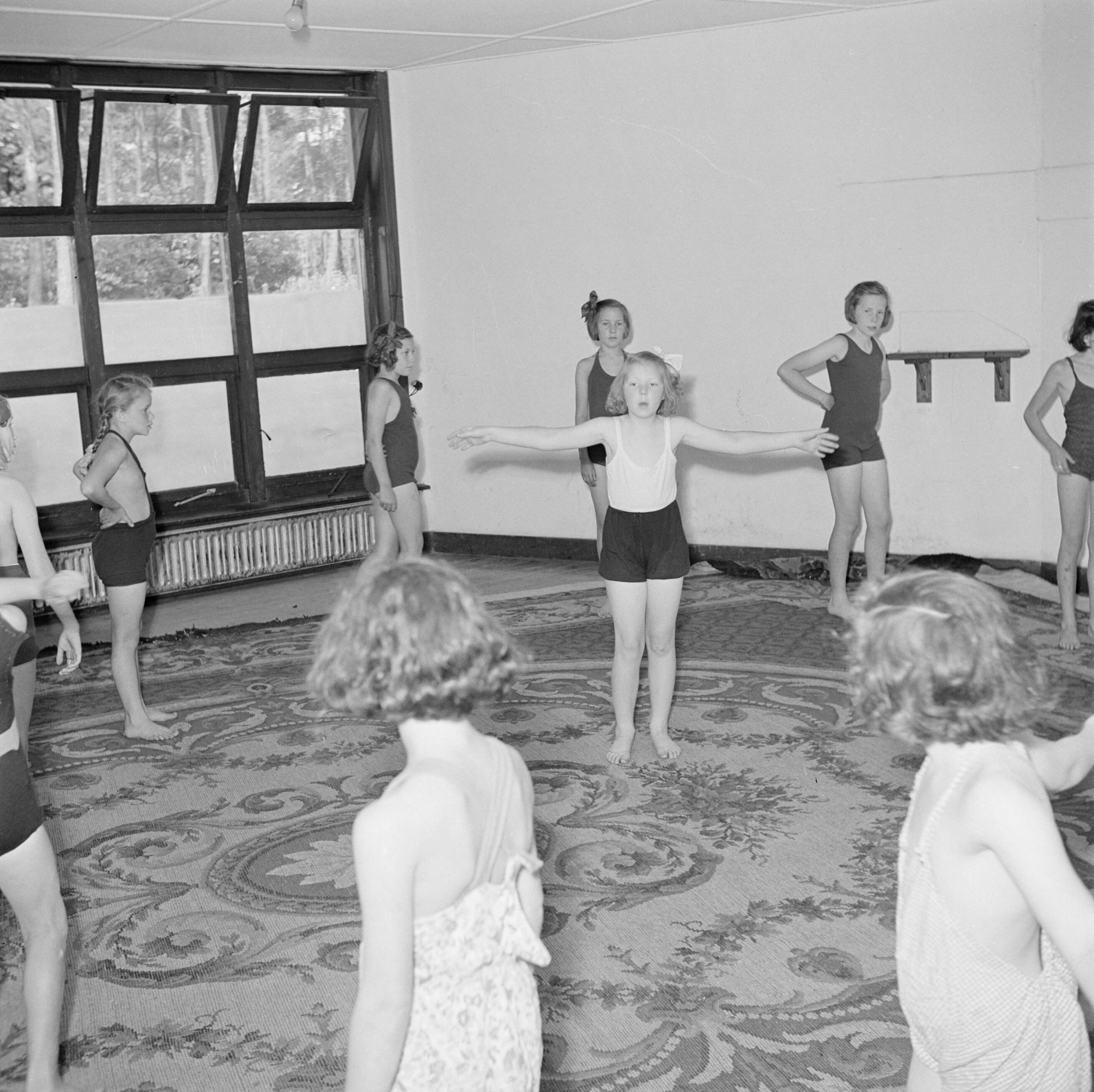 Prinses Beatrix en prinses Irene op de Werkplaats Kindergemeenschap van Kees Boeke te Bilthoven — Prinses Beatrix en andere leerlingen tijdens de gymnastiekles — Foto: Poll, Willem van de. Licentie: Set B: Rechtenvrij / Publiek Domein. Bron: Nationaal Archief. http://hdl.handle.net/10648/aee813b6-d0b4-102d-bcf8-003048976d84