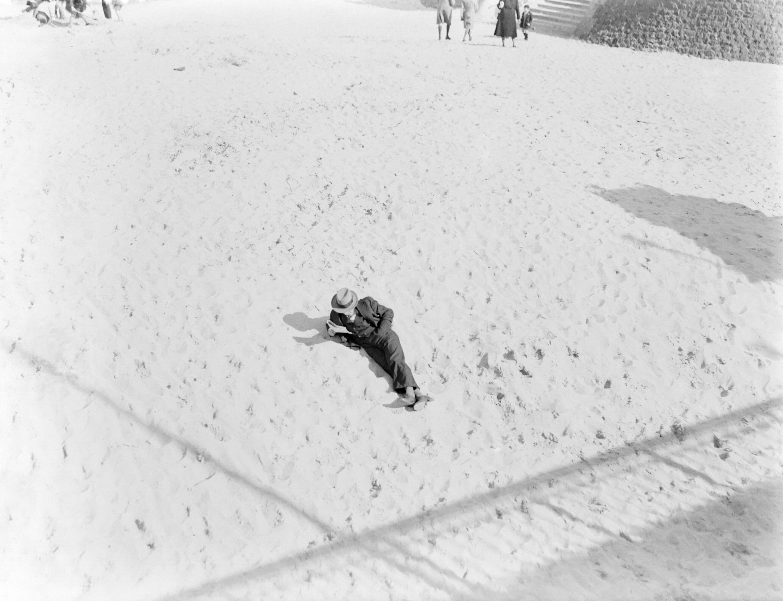 Scheveningen. — Een heer liggend in het zand van het verlaten strand van Scheveningen — Foto: Poll, Willem van de. Licentie: Set B: Rechtenvrij / Publiek Domein. Bron: Nationaal Archief. http://hdl.handle.net/10648/aeaa2128-d0b4-102d-bcf8-003048976d84