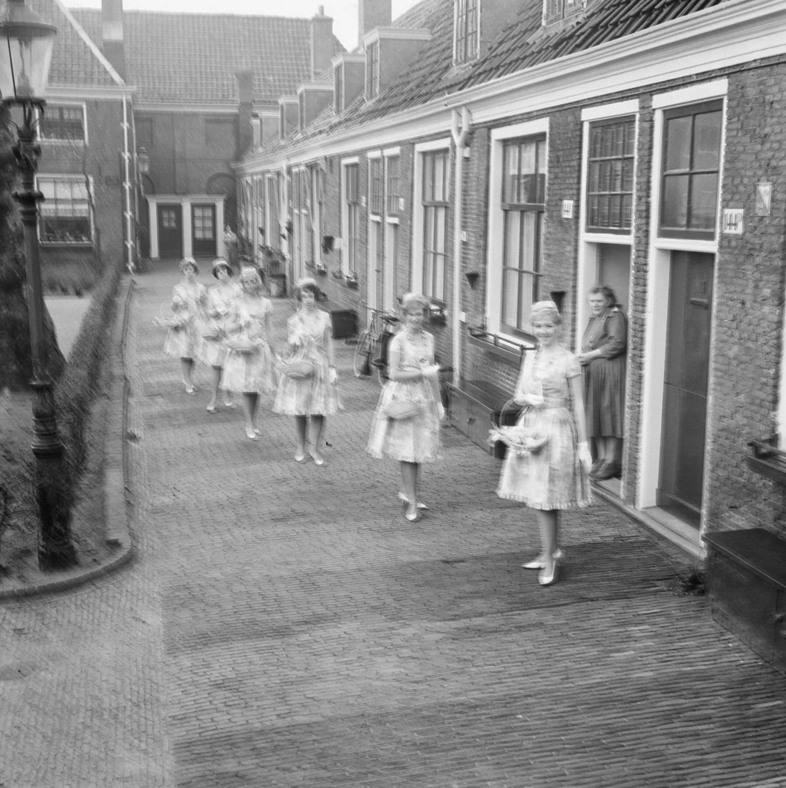 Fotocollectie Anefo — Haarlemse bloemenmeisjes in nieuw pakje, hun nieuwe Boussac katoenen jurkjes. Enkele meisjes op het Proveniershofje te Haarlem — Foto: Nijs, Jac. de / Anefo. Licentie: Set B: Rechtenvrij / Publiek Domein. Bron: Nationaal Archief. http://hdl.handle.net/10648/aa2e6b0e-d0b4-102d-bcf8-003048976d84