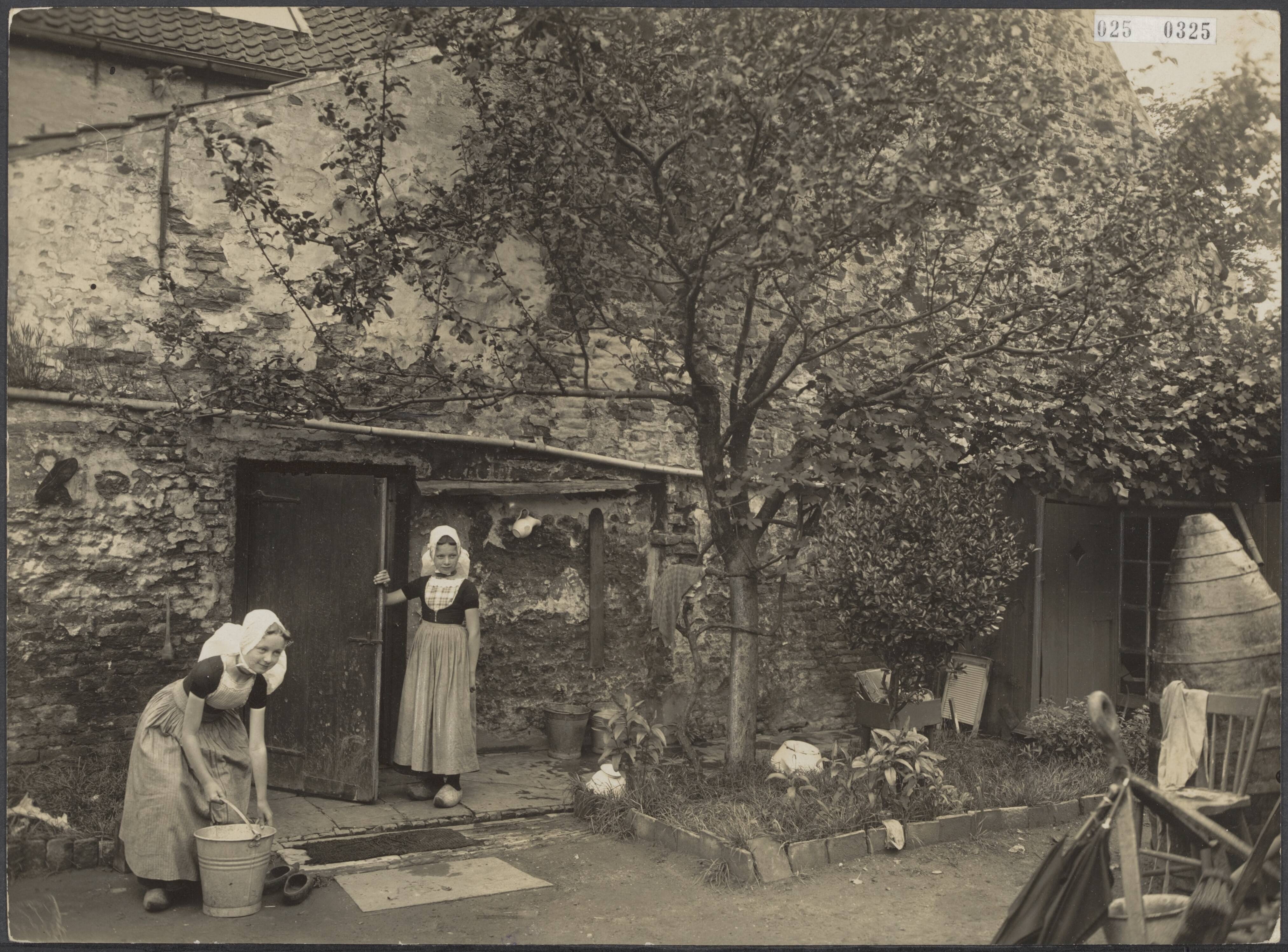 Fotocollectie Elsevier Binnenland — Meisjes in een tuintje in een achterbuurt van de markt van Veere — Foto: Favier, Adriaan. Licentie: Set B: Rechtenvrij / Publiek Domein. Bron: Nationaal Archief. http://hdl.handle.net/10648/adda3558-d0b4-102d-bcf8-003048976d84