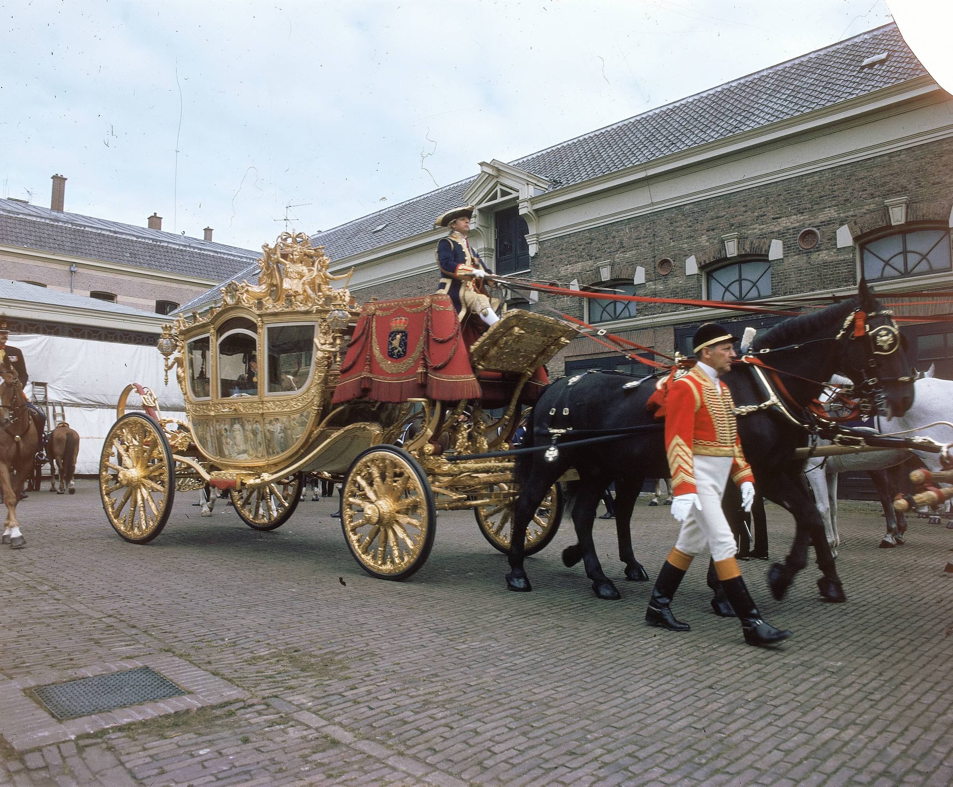 Fotocollectie RVD / Koninklijk Huis — Prinsjesdag - Gouden koets met koetsier, stalpersoneel en paarden op de binnenplaats van de koninklijke stallen aan de Noordwal in Den Haag — Foto: Mastenbroek, Cees / RVD. Licentie: Set B: Rechtenvrij / Publiek Domein. Bron: Nationaal Archief. http://hdl.handle.net/10648/afb26ecc-d0b4-102d-bcf8-003048976d84