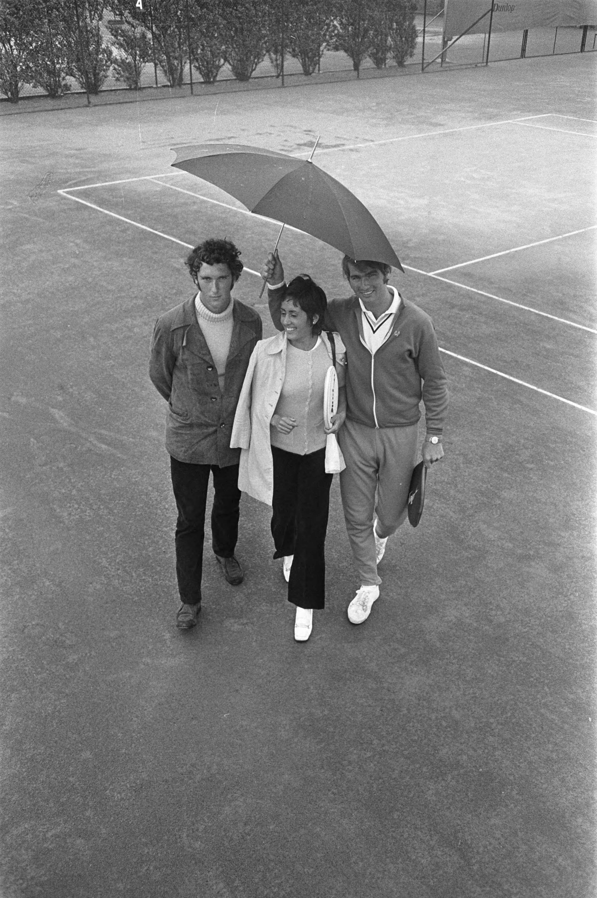 Fotocollectie Anefo — Nationale tenniskampioenschappen op METS-banen te Scheveningen; Fred Hemmes, Judith Salome, Jan Hordijk met paraplu — Foto: Koch, Eric / Anefo. Licentie: Set B: Rechtenvrij / Publiek Domein. Bron: Nationaal Archief. http://hdl.handle.net/10648/ab9f2eba-d0b4-102d-bcf8-003048976d84