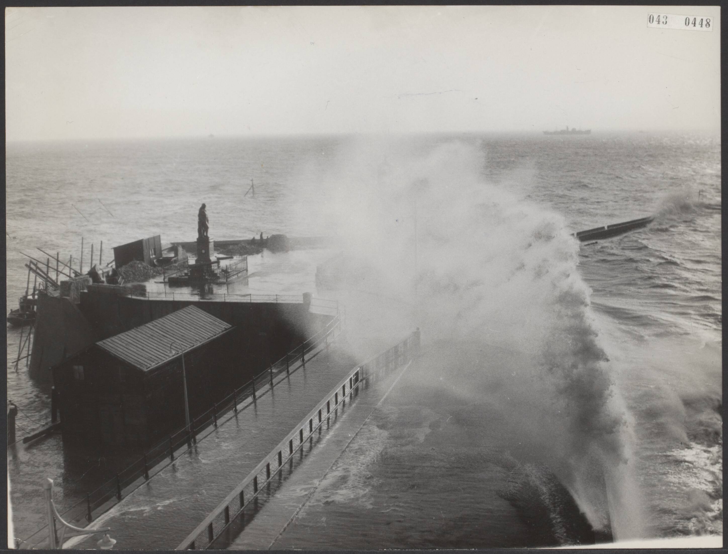 Fotocollectie Elsevier Binnenland — De storm in Vlissingen was zo hevig dat de kruiser Hr. Ms. "De Ruyter" niet kon binnen lopen. De storm raast over De Ruyterboulevard met aan de kop het standbeeld van De Ruyter — Foto: Fotograaf Onbekend / Anefo. Licentie: Set B: Rechtenvrij / Publiek Domein. Bron: Nationaal Archief. http://hdl.handle.net/10648/adf904d8-d0b4-102d-bcf8-003048976d84