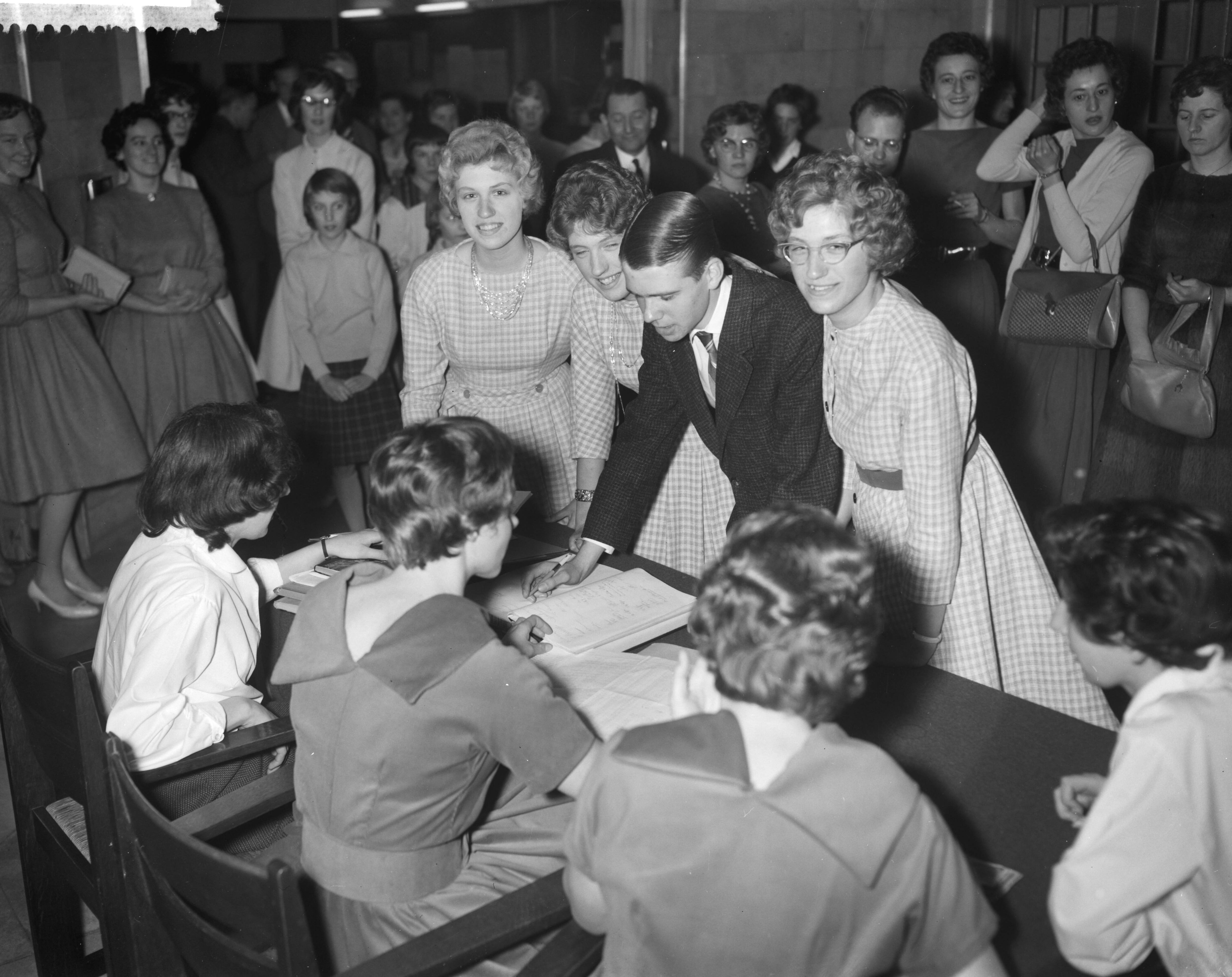 Fotocollectie Anefo — Zwolse vierling Kiffers sc hrijven zich in voor de conferentie van de Nederlandse Vereniging van Tweelingen in Woudschoten. Vlnr. Ellen, Dorothée, Han en Rini — Foto: Bilsen, Joop van / Anefo. Licentie: Set B: Rechtenvrij / Publiek Domein. Bron: Nationaal Archief. http://hdl.handle.net/10648/a9a8a794-d0b4-102d-bcf8-003048976d84