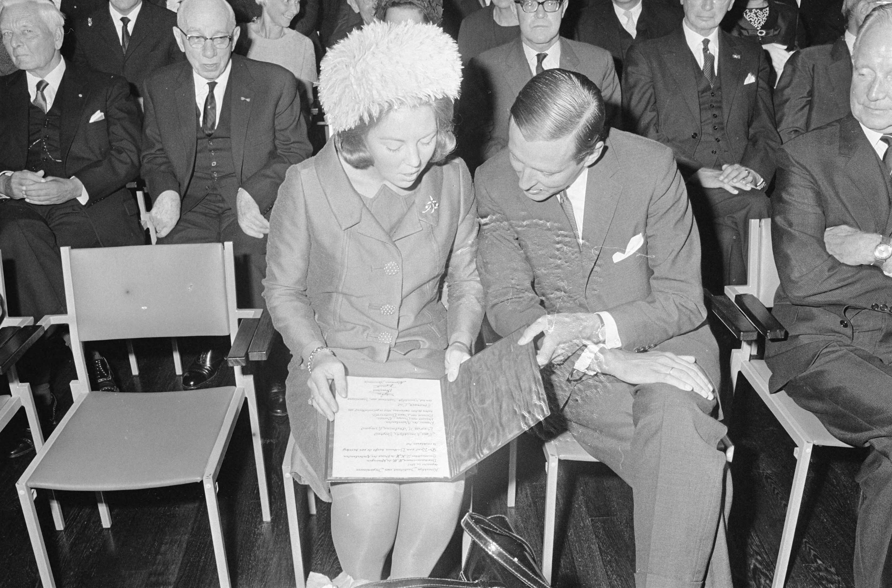 Prinses Beatrix lid van het Koninklijk instituut van Ingenieurs te Den Haag — Prinses Beatrix en prins Claus bekijken de zojuist door de prinses ontvangen oorkonde — Foto: Fotograaf Onbekend / Anefo. Licentie: Set B: Rechtenvrij / Publiek Domein. Bron: Nationaal Archief. http://hdl.handle.net/10648/aafbddb4-d0b4-102d-bcf8-003048976d84