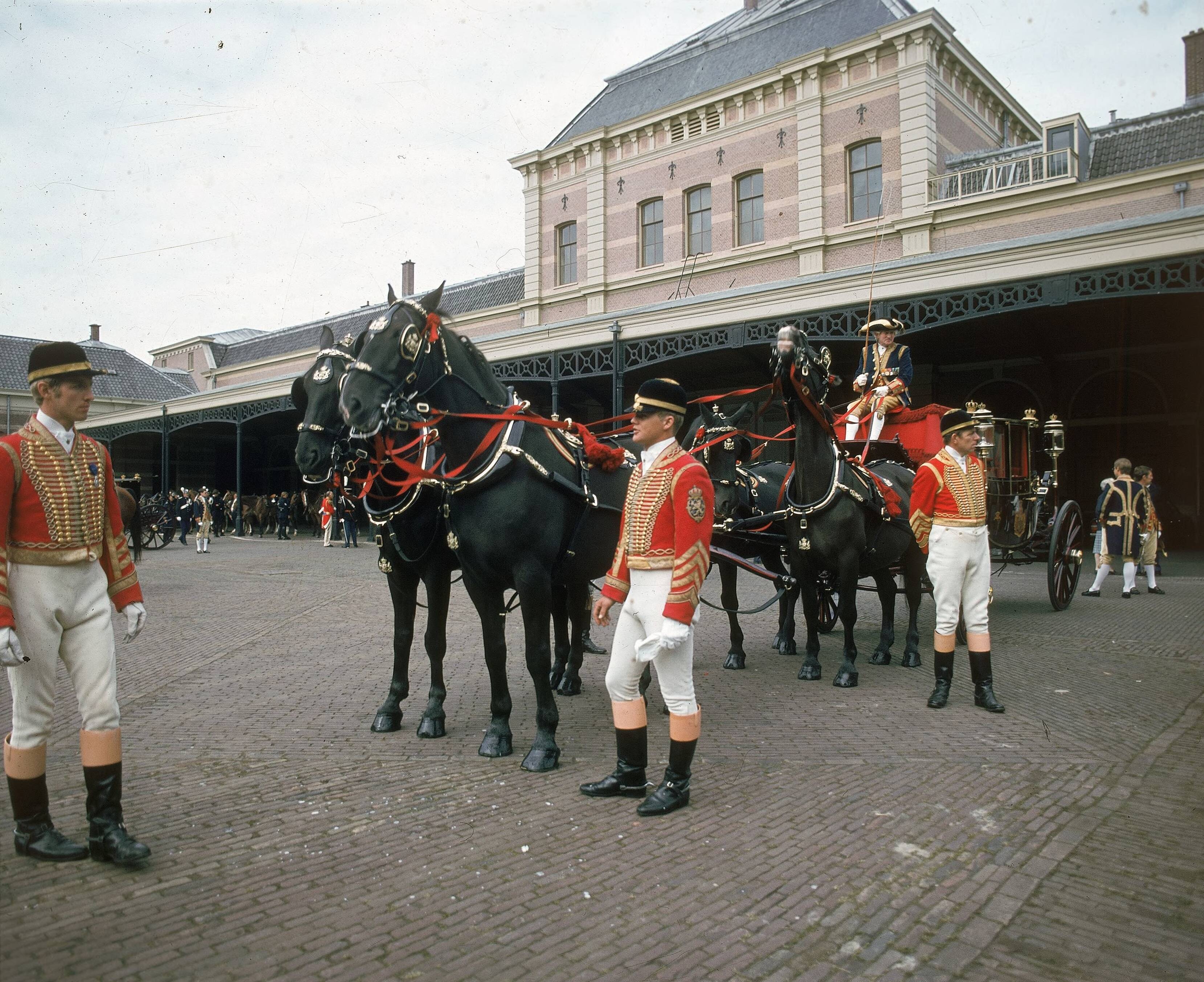 Fotocollectie RVD / Koninklijk Huis — Prinsjesdag - volgrijtuig met koetsier, lakeien, stalpersoneel en paarden op de binnenplaats van de koninklijke stallen aan de Noordwal in Den Haag — Foto: Mastenbroek, Cees / RVD. Licentie: Set B: Rechtenvrij / Publiek Domein. Bron: Nationaal Archief. http://hdl.handle.net/10648/afb26e0e-d0b4-102d-bcf8-003048976d84