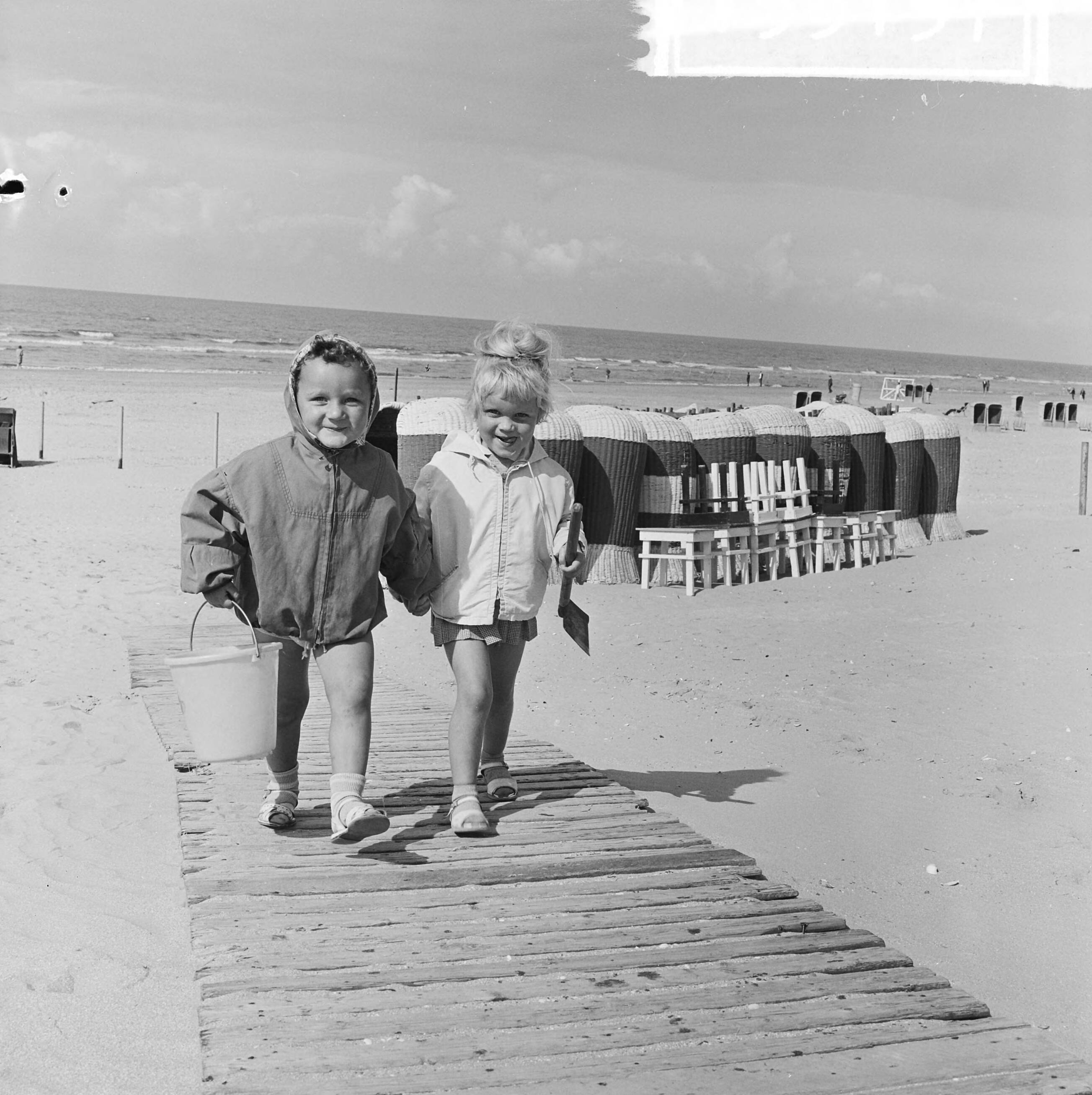Fotocollectie Anefo — Badseizoen ten einde. Michiel en Joeki bij het verlaten van het Zandvoortse strand — Foto: Koch, Eric / Anefo. Licentie: Set B: Rechtenvrij / Publiek Domein. Bron: Nationaal Archief. http://hdl.handle.net/10648/aa45080a-d0b4-102d-bcf8-003048976d84