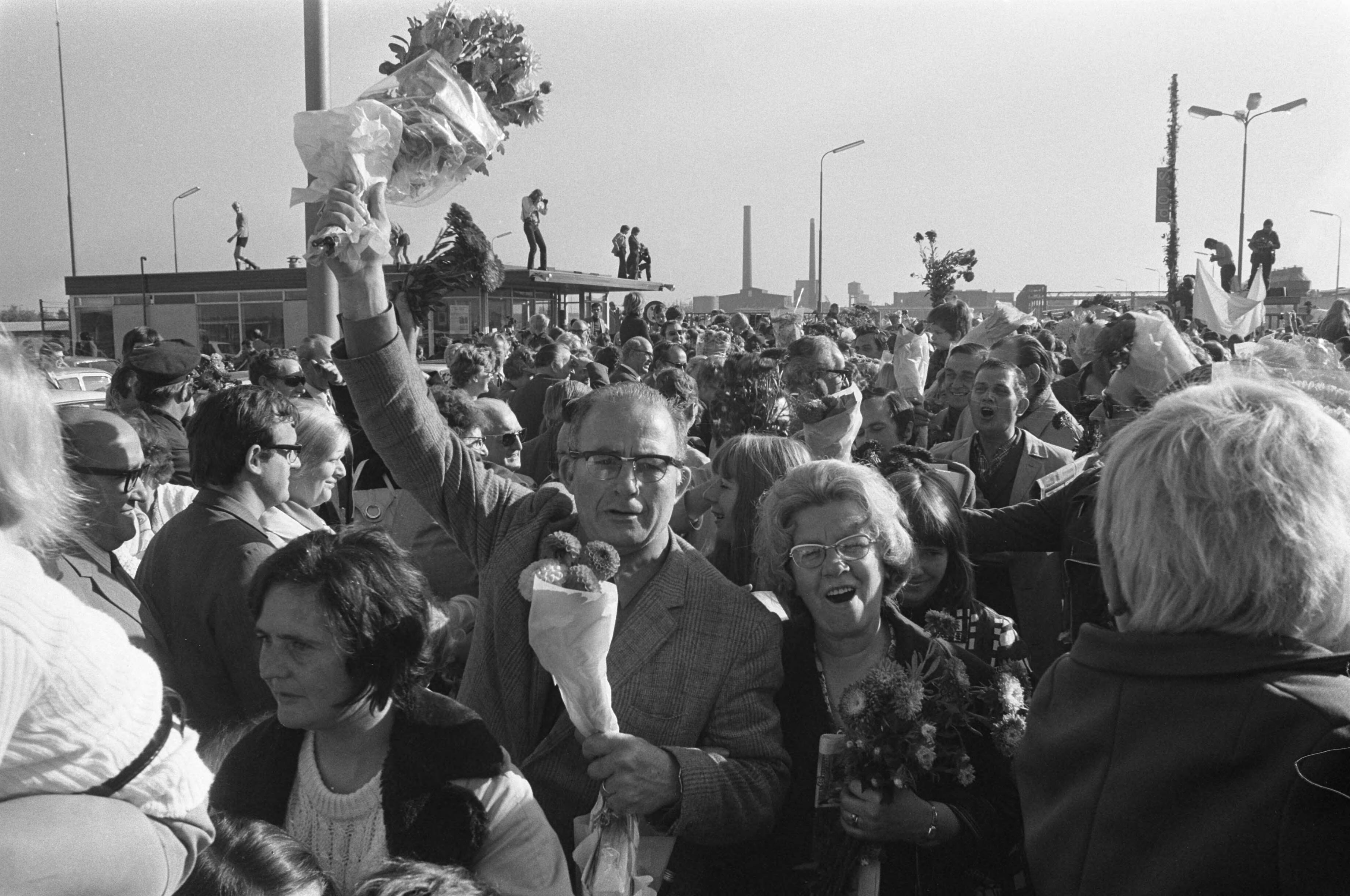 Fotocollectie Anefo — Bezetting ENKA Breda opgeheven, bezetters komen naar buiten met bloemen — Foto: Verhoeff, Bert / Anefo. Licentie: Set B: Rechtenvrij / Publiek Domein. Bron: Nationaal Archief. http://hdl.handle.net/10648/abf6f05a-d0b4-102d-bcf8-003048976d84