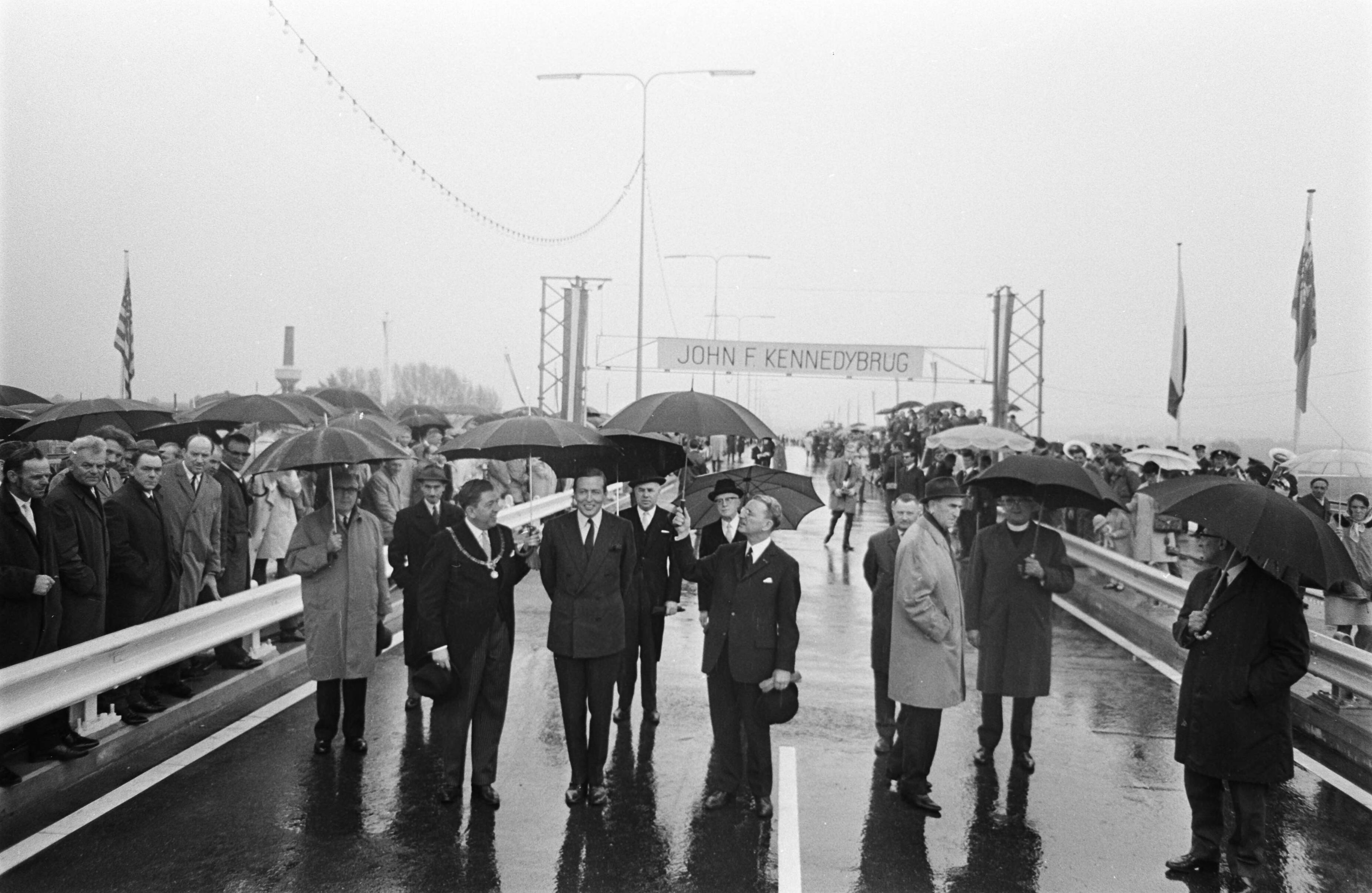 Fotocollectie Anefo — Prins Claus opende John F. Kennedy brug te Maastricht. Na de opening wandelde prins Claus over de nieuwe brug. Links met ambtsketen: burgemeester Baeten — Foto: Nijs, Jac. de / Anefo. Licentie: Set B: Rechtenvrij / Publiek Domein. Bron: Nationaal Archief. http://hdl.handle.net/10648/ab3fbeee-d0b4-102d-bcf8-003048976d84