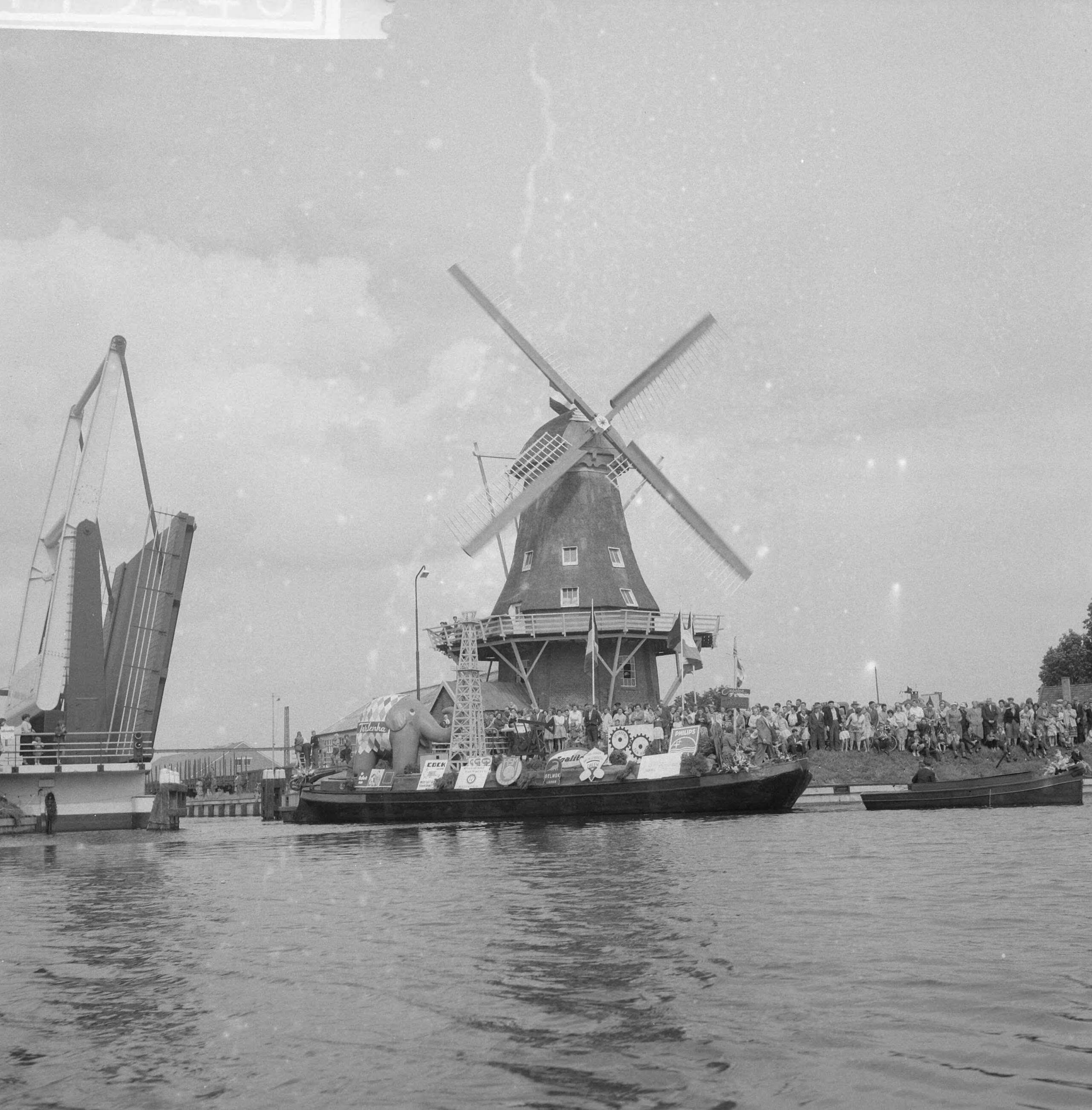 Burgemeester Van Hall bezoekt Nieuw Amsterdam, dat 100 jaar bestaat — Burgemeester Van Hall bezoekt Nieuw Amsterdam, dat 100 jaar bestaat. Turfschip vaart door brug. Op achtergrond molen — Foto: Rossem, Wim van / Anefo. Licentie: Set B: Rechtenvrij / Publiek Domein. Bron: Nationaal Archief. http://hdl.handle.net/10648/a9b75348-d0b4-102d-bcf8-003048976d84