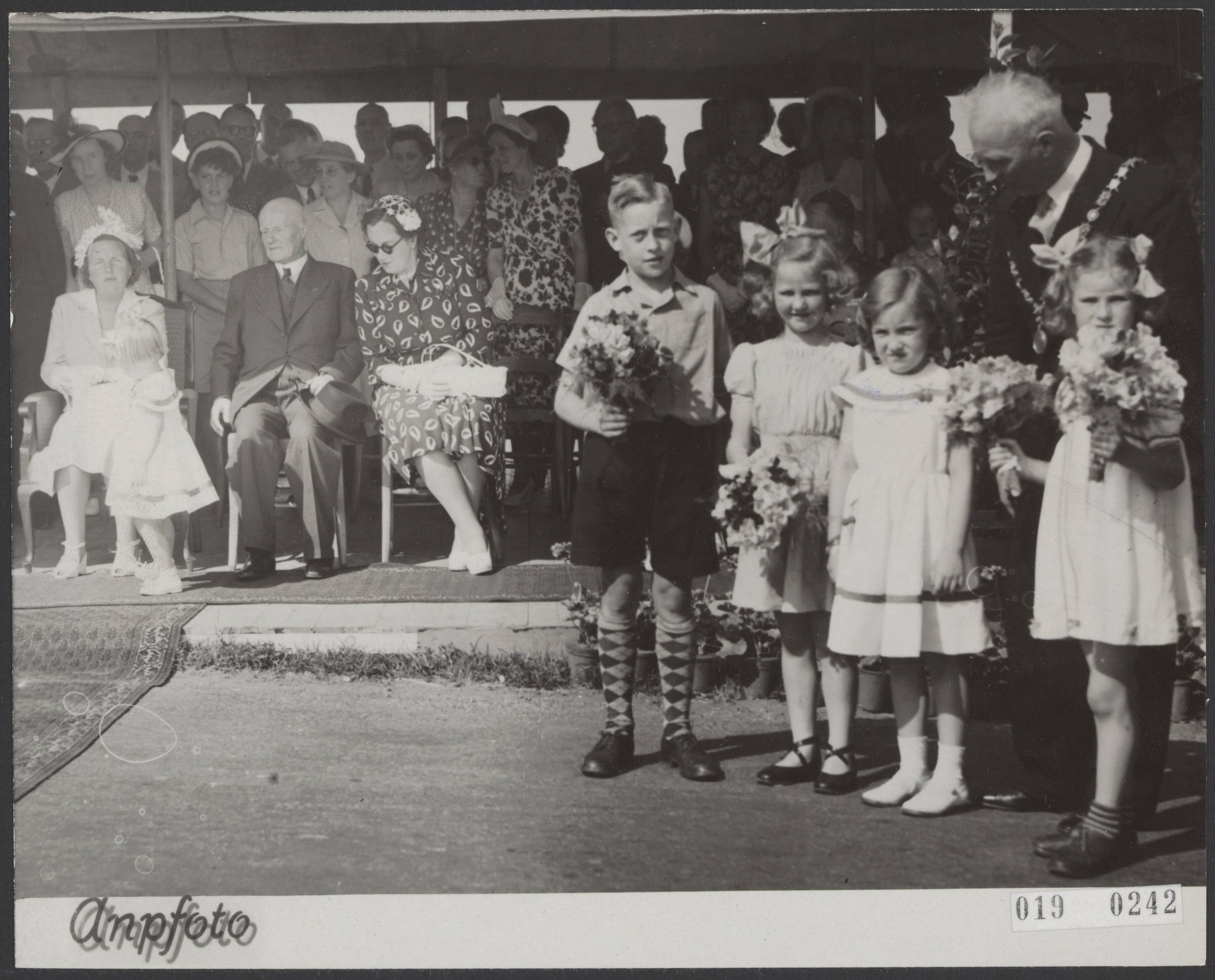 Fotocollectie Elsevier Binnenland — Prinses Margriet heeft, bijgestaan door oud-minister L.N. Deckers, voorztitter van de A.N.V.V., op de Woerdersluis te Spaarndam een monument, een jongensfiguur voorstellende, onthuld. Dit monument symboliseert de eeuwigdurende strijd van de Nederlanders tegen het water. Temidden van drie andere kinderen wacht prinses Margriet op het moment waarop zij zich van haar eerste officiële taak zal gaan kwijten. Geheel links koningin Juliana en prinses Marijke (Christina) — Foto: ANP / RVD of rechtenvrij. Licentie: Set B: Rechtenvrij / Publiek Domein. Bron: Nationaal Archief. http://hdl.handle.net/10648/adc5ec38-d0b4-102d-bcf8-003048976d84