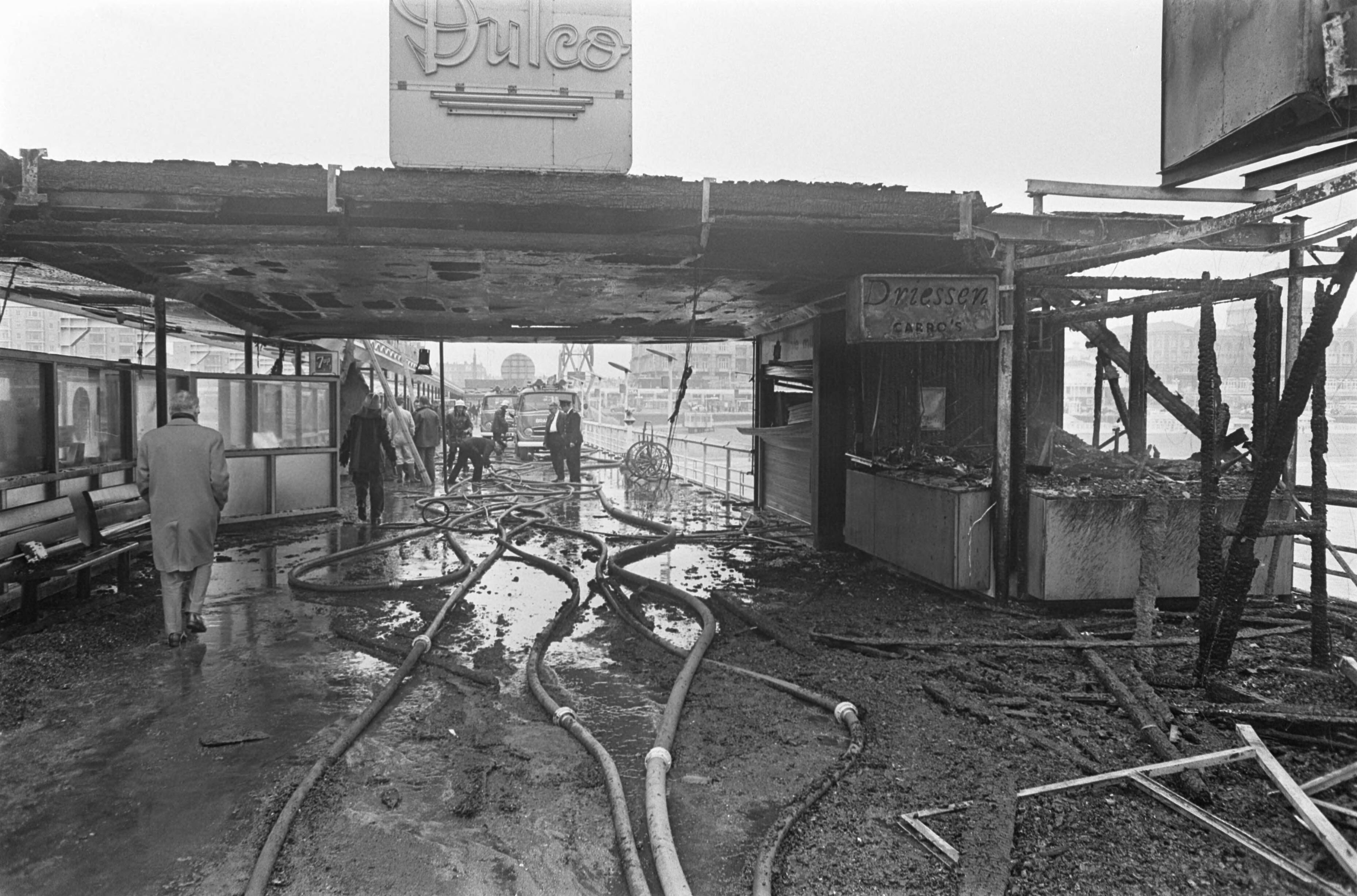 Fotocollectie Anefo — Brand op pier van Scheveningen. Op de hoofdpier brandden de winkeltjes geheel uit — Foto: Nijs, Jac. de / Anefo. Licentie: Set B: Rechtenvrij / Publiek Domein. Bron: Nationaal Archief. http://hdl.handle.net/10648/ab3de146-d0b4-102d-bcf8-003048976d84