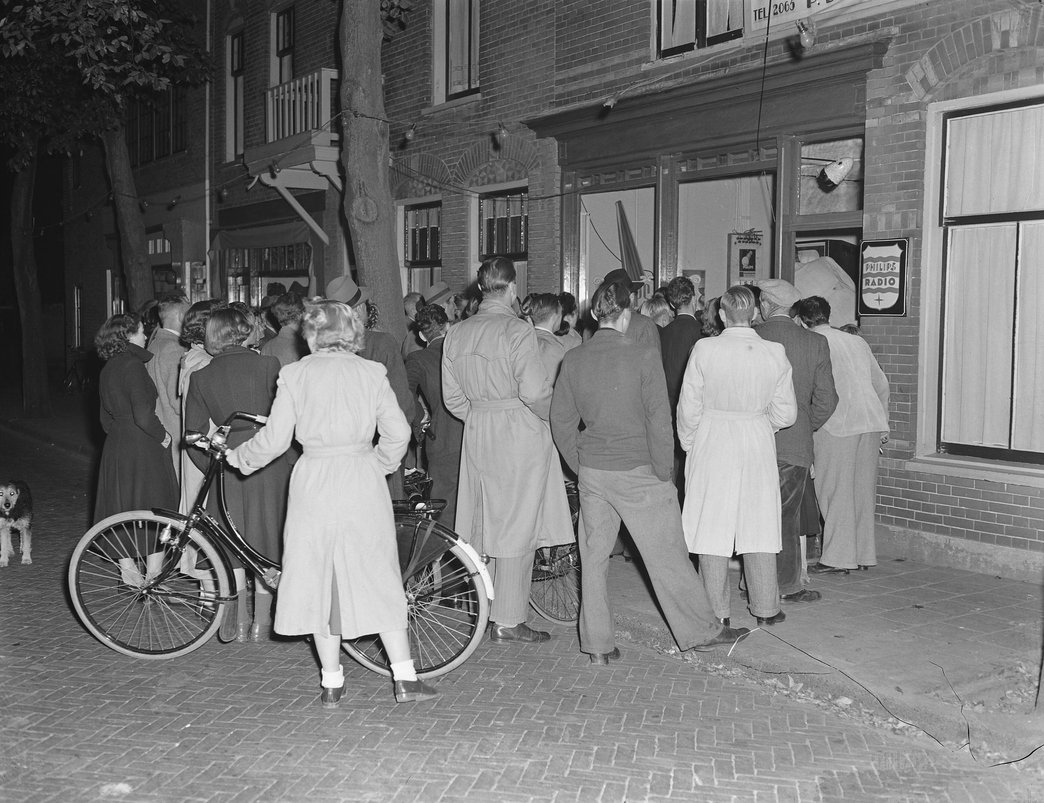 Fotocollectie Anefo — Publiek kijkt naar televisie in een etalage te Zandvoort — Foto: Pot, Harry / Anefo. Licentie: Set B: Rechtenvrij / Publiek Domein. Bron: Nationaal Archief. http://hdl.handle.net/10648/a8f07a20-d0b4-102d-bcf8-003048976d84