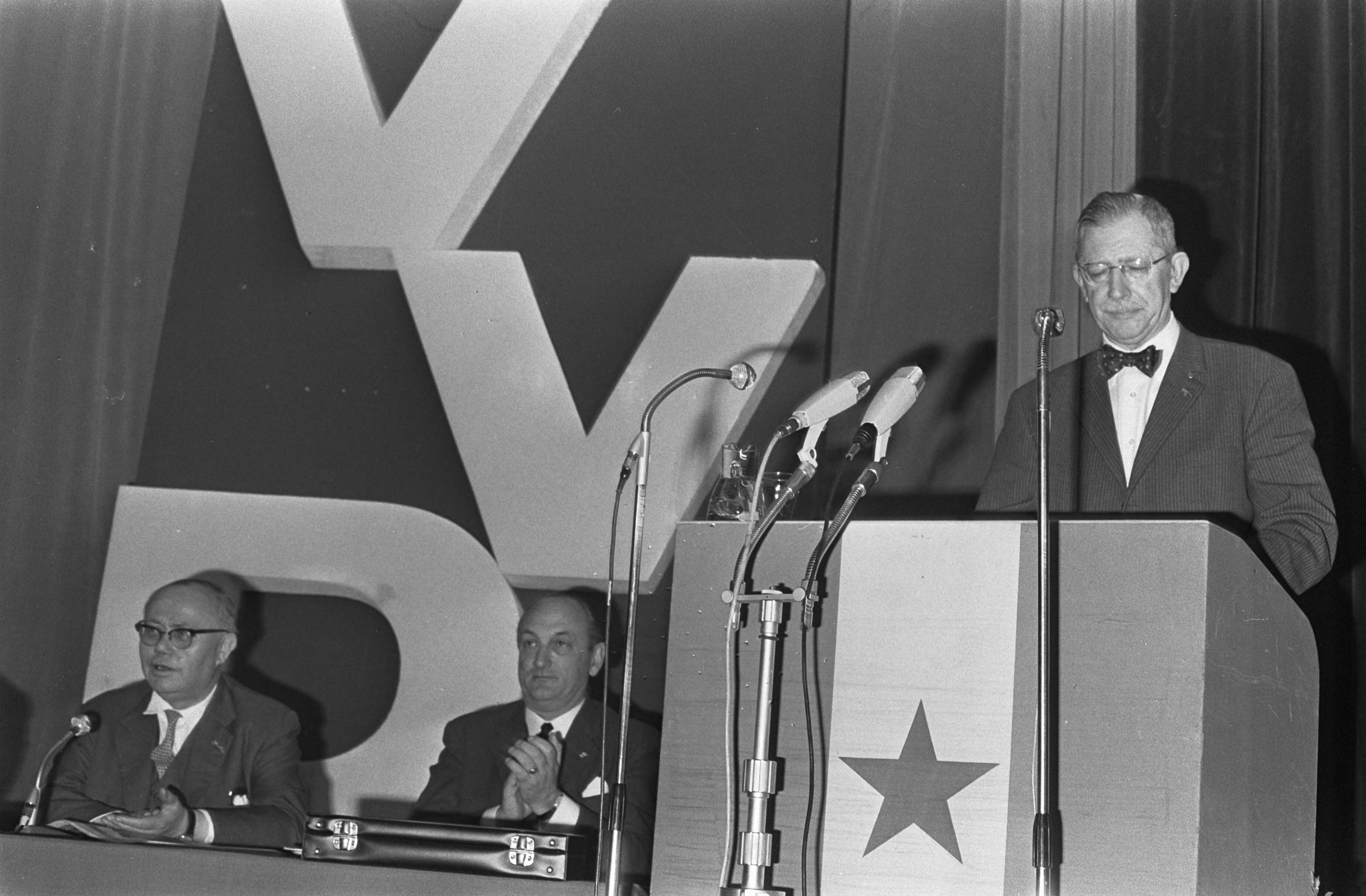 Fotocollectie Anefo — VVD-jaarvergadering te Maastricht. Voorzitter van der Pols tijdens openingsrede, naast hem (vrnl) mr. Toxopeus en dhr. van Riel — Foto: Nijs, Jac. de / Anefo. Licentie: Set B: Rechtenvrij / Publiek Domein. Bron: Nationaal Archief. http://hdl.handle.net/10648/ab3bfe62-d0b4-102d-bcf8-003048976d84