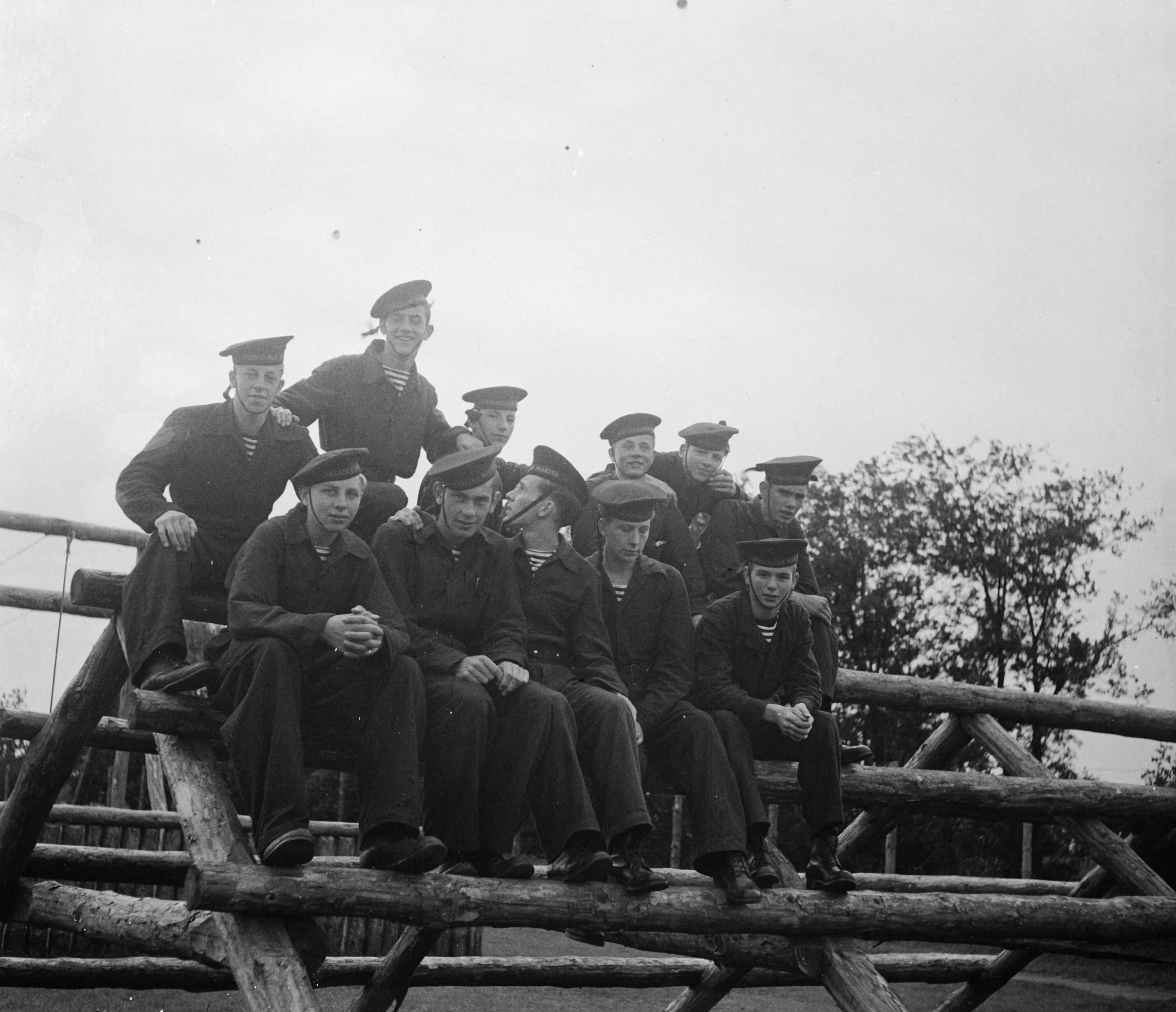 MOK Hilversum 1948 — MOK Hilversum. Matrozen groepje op balken — Foto: Steenkamp, B.J.J. (Ben) / Anefo. Licentie: Set B: Rechtenvrij / Publiek Domein. Bron: Nationaal Archief. http://hdl.handle.net/10648/a8bd979a-d0b4-102d-bcf8-003048976d84