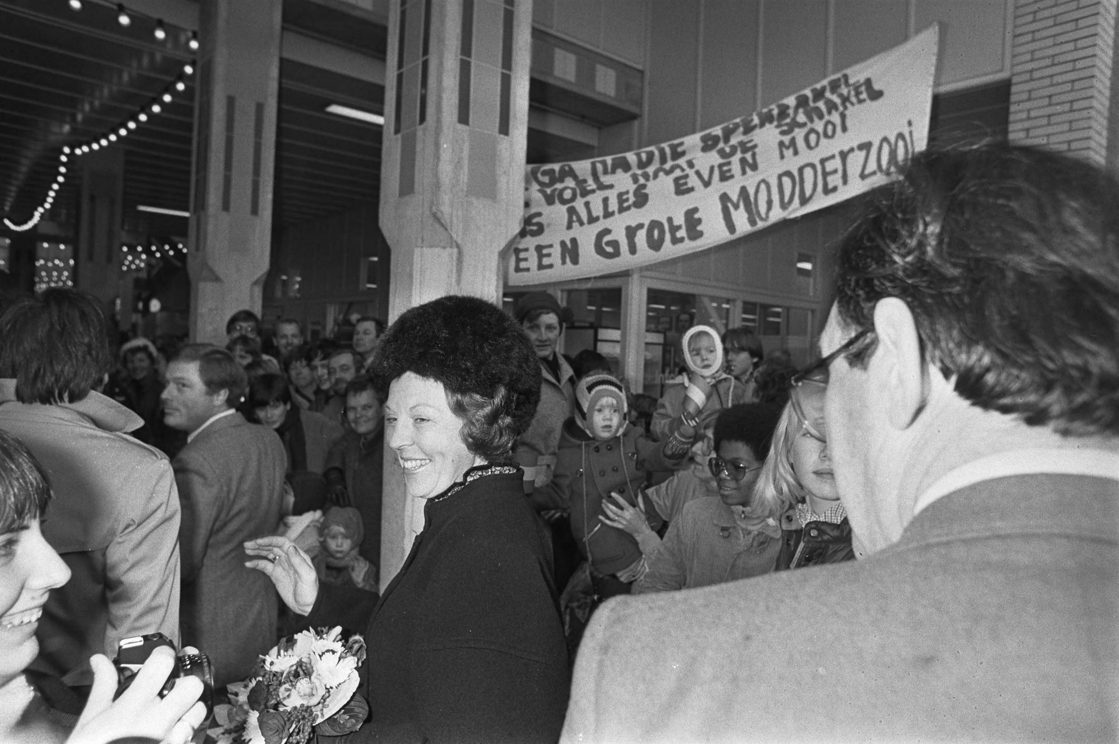 Koningin Beatrix bezoekt Almere in verband met het 5-jarig bestaan — In Almere Stad hingen spandoeken omdat de route van Beatrix schoon was en de rest modderig; rechts Han Lammers — Foto: Croes, Rob C. / Anefo. Licentie: Set B: Rechtenvrij / Publiek Domein. Bron: Nationaal Archief. http://hdl.handle.net/10648/ad09fbd6-d0b4-102d-bcf8-003048976d84