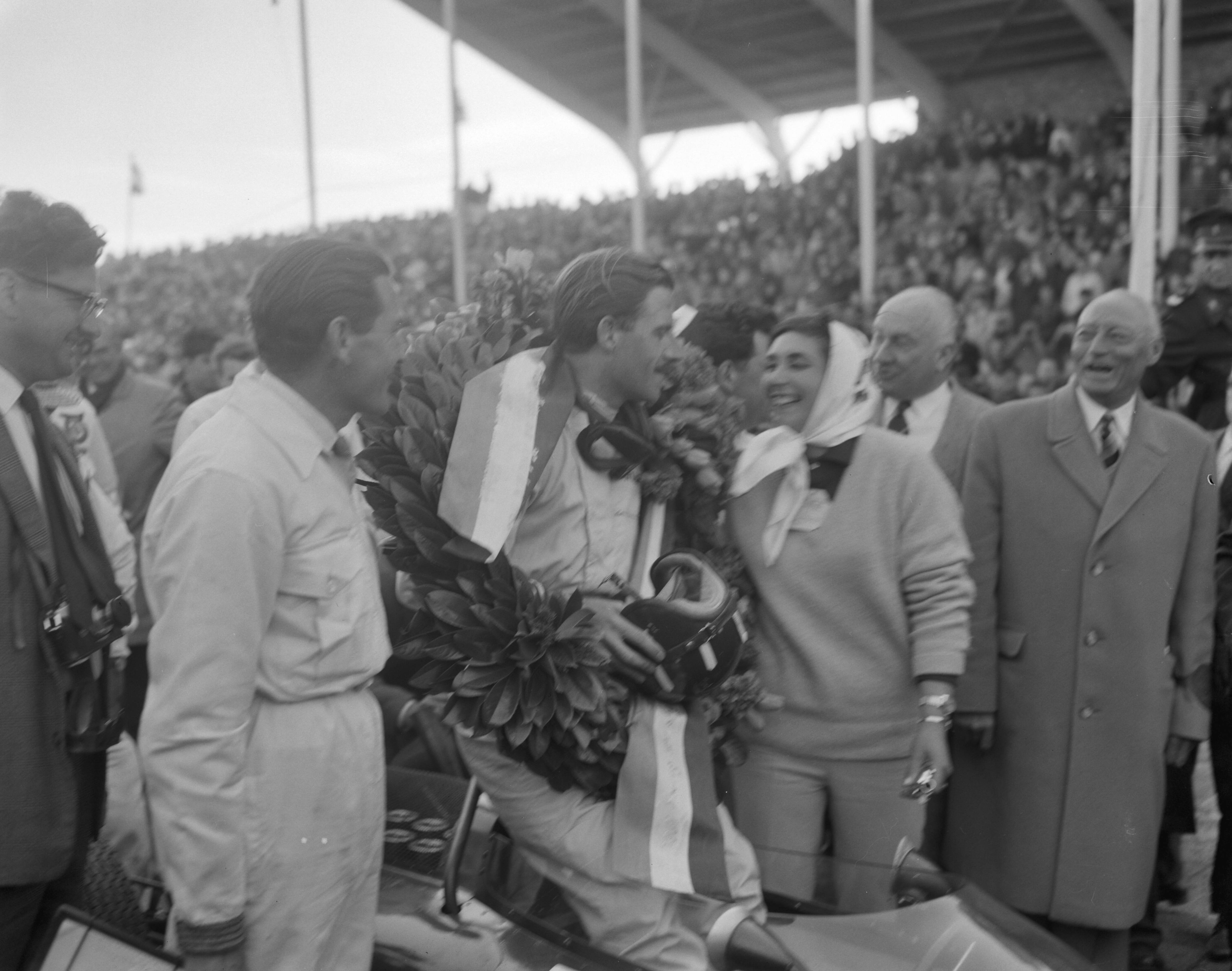 Grand Prix Zandvoort 1962 — Grand Prix van Zandvoort. Huldiging winnaar Graham Hill met naast zich zijn vrouw Bette — Foto: Bilsen, Joop van / Anefo. Licentie: Set B: Rechtenvrij / Publiek Domein. Bron: Nationaal Archief. http://hdl.handle.net/10648/aa09321c-d0b4-102d-bcf8-003048976d84