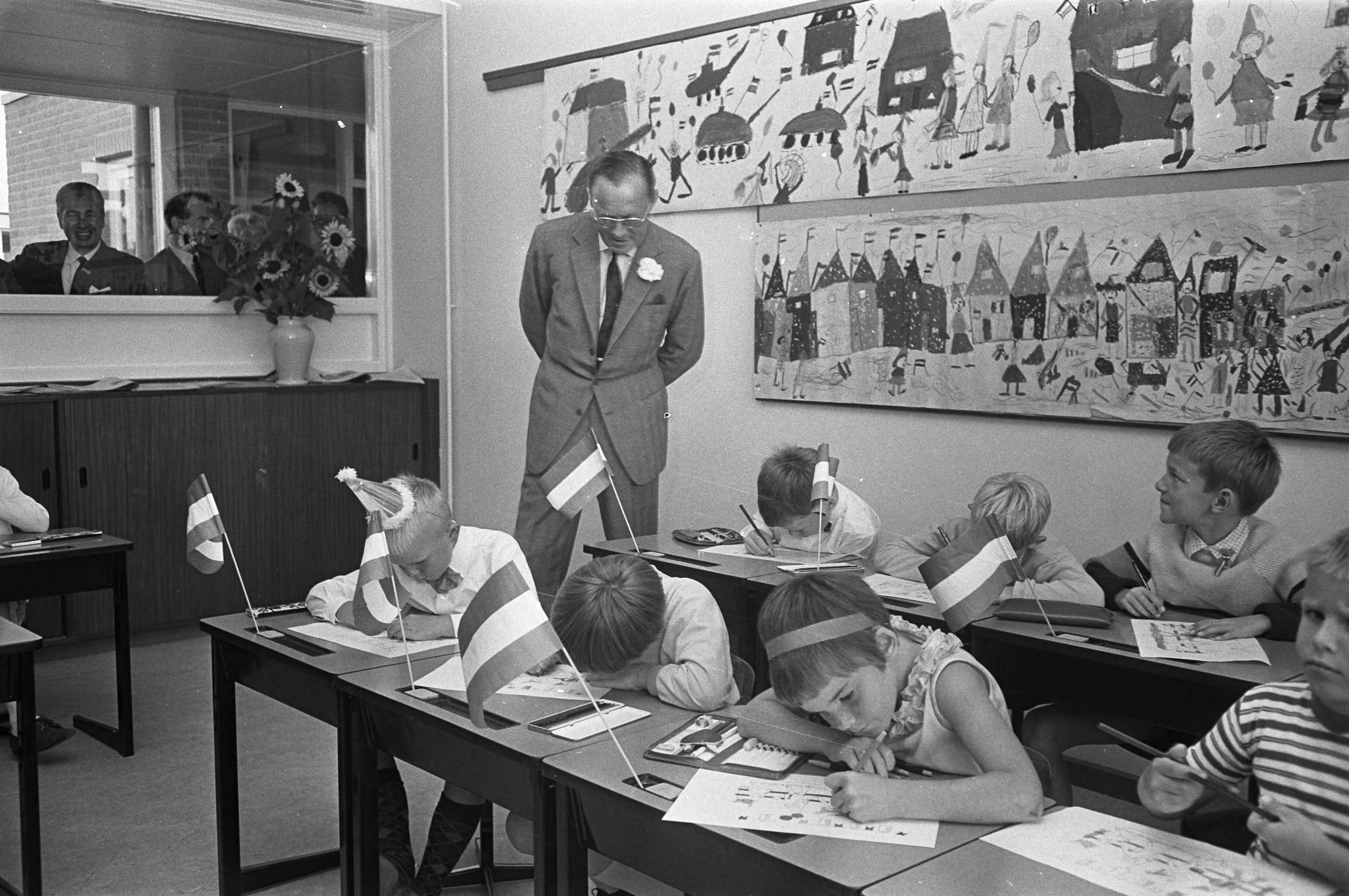 Prins Bernhard opent de Prins Bernhard school te Leeuwarden — De Prins kijkt toe bij kinderen die tekeningen maken — Foto: Fotograaf Onbekend / Anefo. Licentie: Set B: Rechtenvrij / Publiek Domein. Bron: Nationaal Archief. http://hdl.handle.net/10648/ab4c44d4-d0b4-102d-bcf8-003048976d84