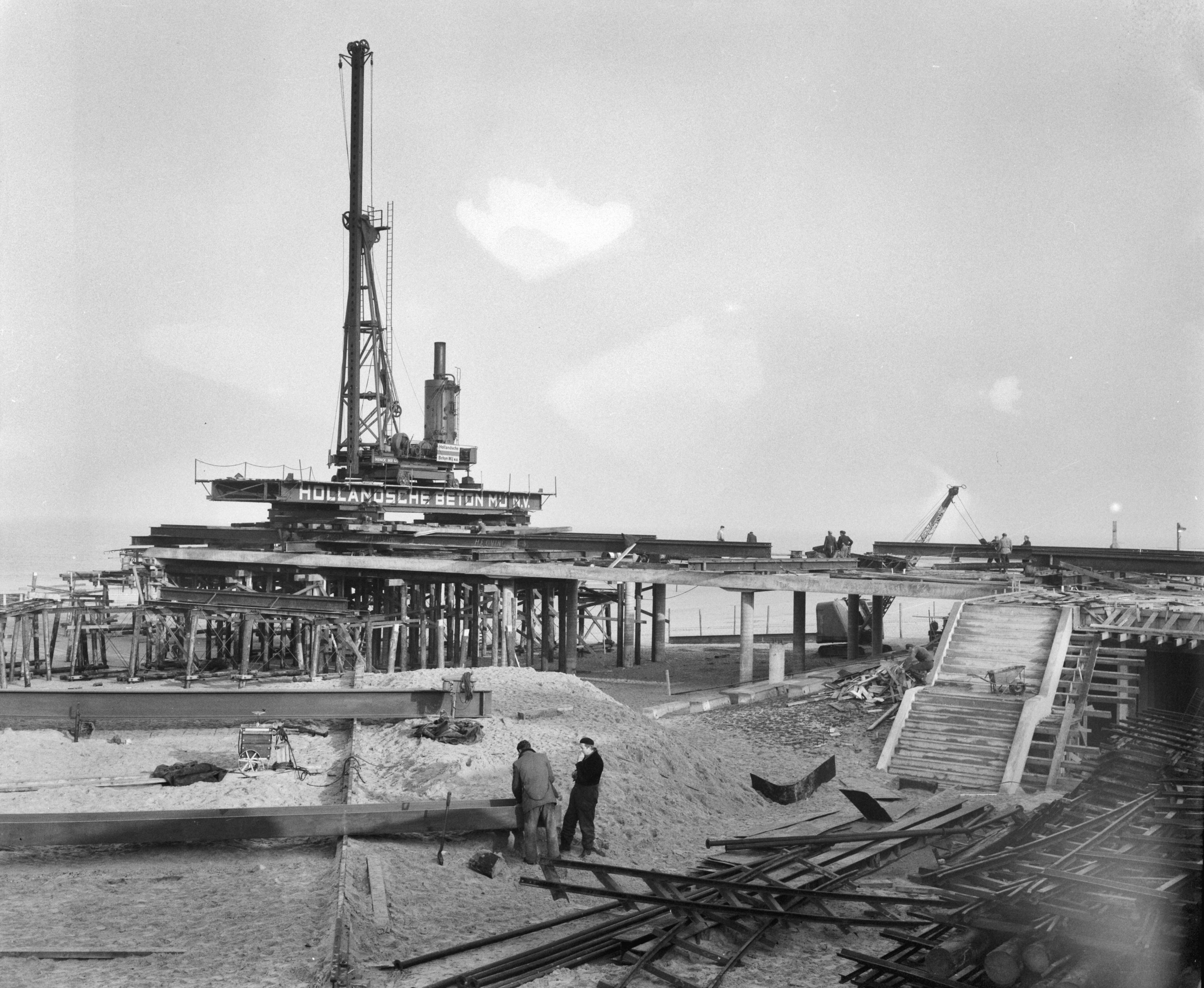 Fotocollectie Anefo — Werkzaamheden aan de nieuwe Pier te Scheveningen — Foto: Behrens, Herbert F. / Anefo. Licentie: Set B: Rechtenvrij / Publiek Domein. Bron: Nationaal Archief. http://hdl.handle.net/10648/a9a72ea0-d0b4-102d-bcf8-003048976d84