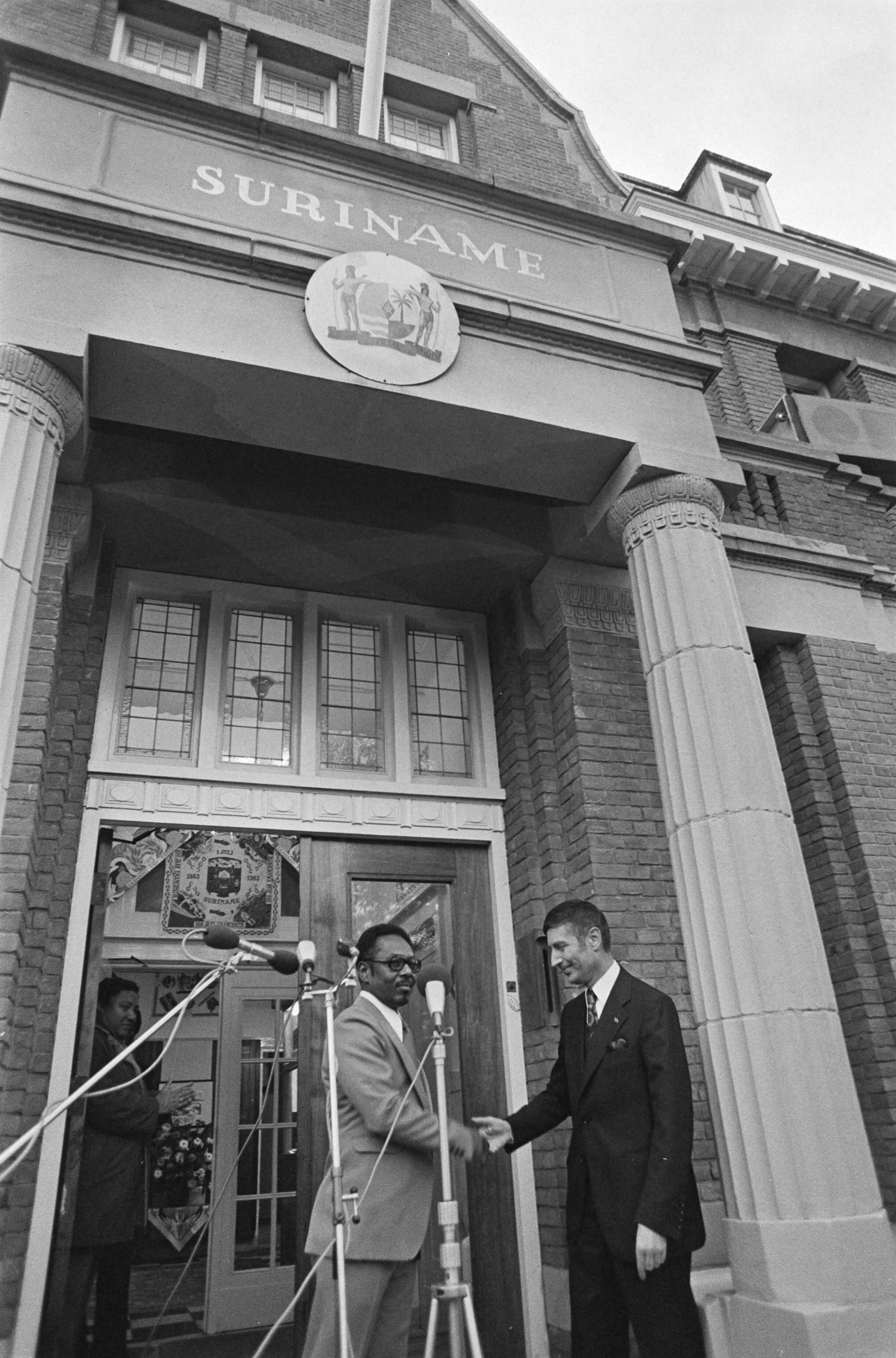 Fotocollectie Anefo — Surinaamse vlag gehesen bij Ambassade Suriname in Den Haag ; minister Van Agt en ambassadeur Van Eer op bordes — Foto: Mieremet, Rob / Anefo. Licentie: Set B: Rechtenvrij / Publiek Domein. Bron: Nationaal Archief. http://hdl.handle.net/10648/ac77d1fc-d0b4-102d-bcf8-003048976d84