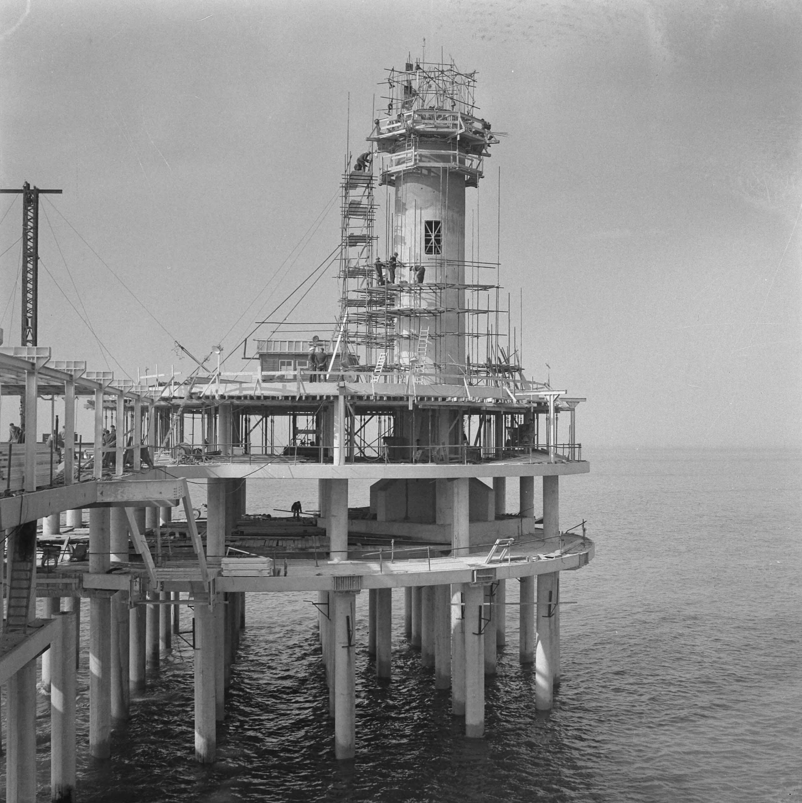Fotocollectie Anefo — Werkzaamheden Pier te Scheveningen. Bouw uitkijktoren op de Pier — Foto: Nijs, Jac. de / Anefo. Licentie: Set B: Rechtenvrij / Publiek Domein. Bron: Nationaal Archief. http://hdl.handle.net/10648/a9d0faa0-d0b4-102d-bcf8-003048976d84