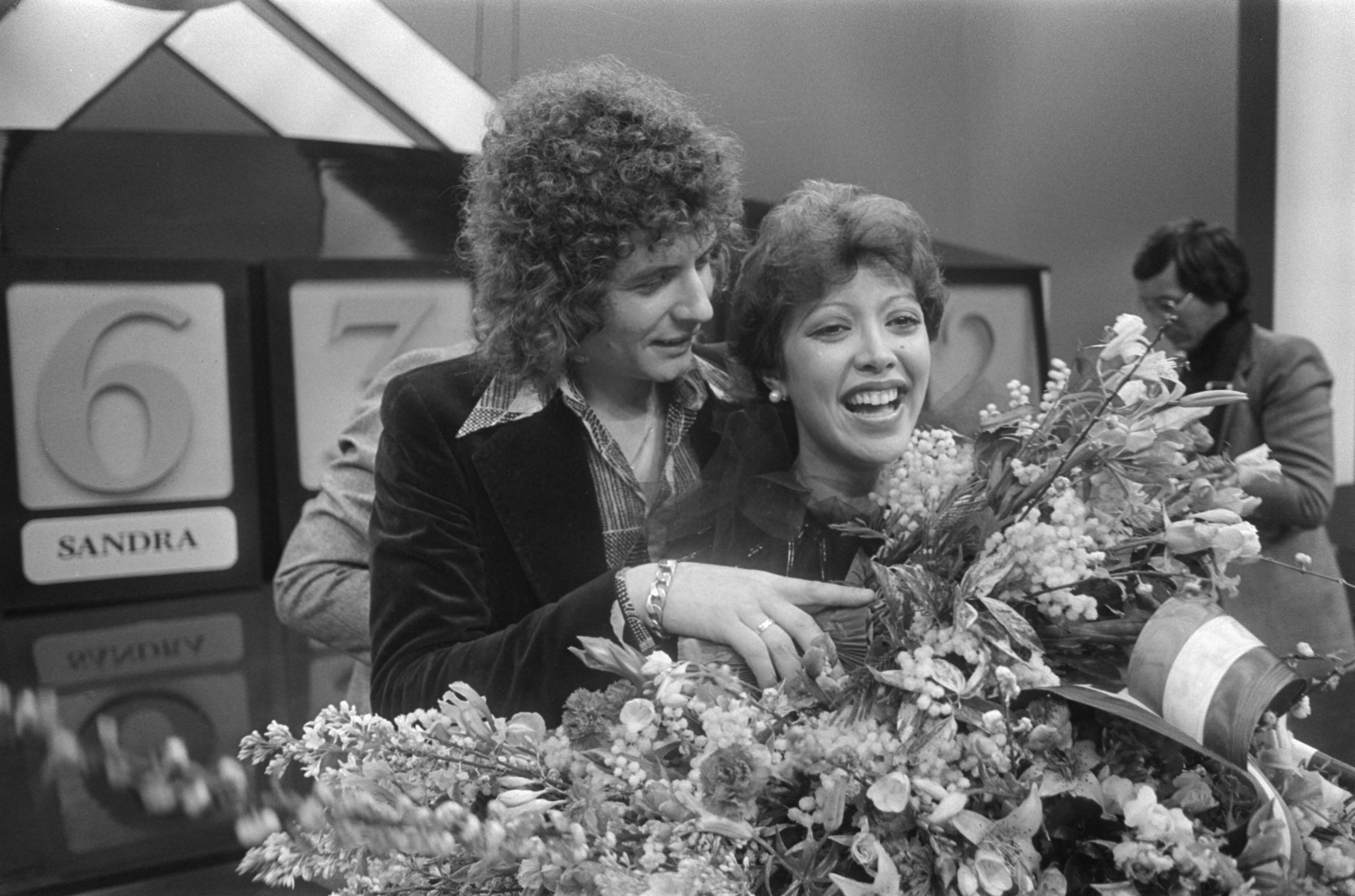 Fotocollectie Anefo — Nationaal Songfestival in Congrescentrum Den Haag ; winnares Sandra met tekstschrijver Hans van Hemert in de bloemen — Foto: Peters, Hans / Anefo. Licentie: Set B: Rechtenvrij / Publiek Domein. Bron: Nationaal Archief. http://hdl.handle.net/10648/ac7d7076-d0b4-102d-bcf8-003048976d84