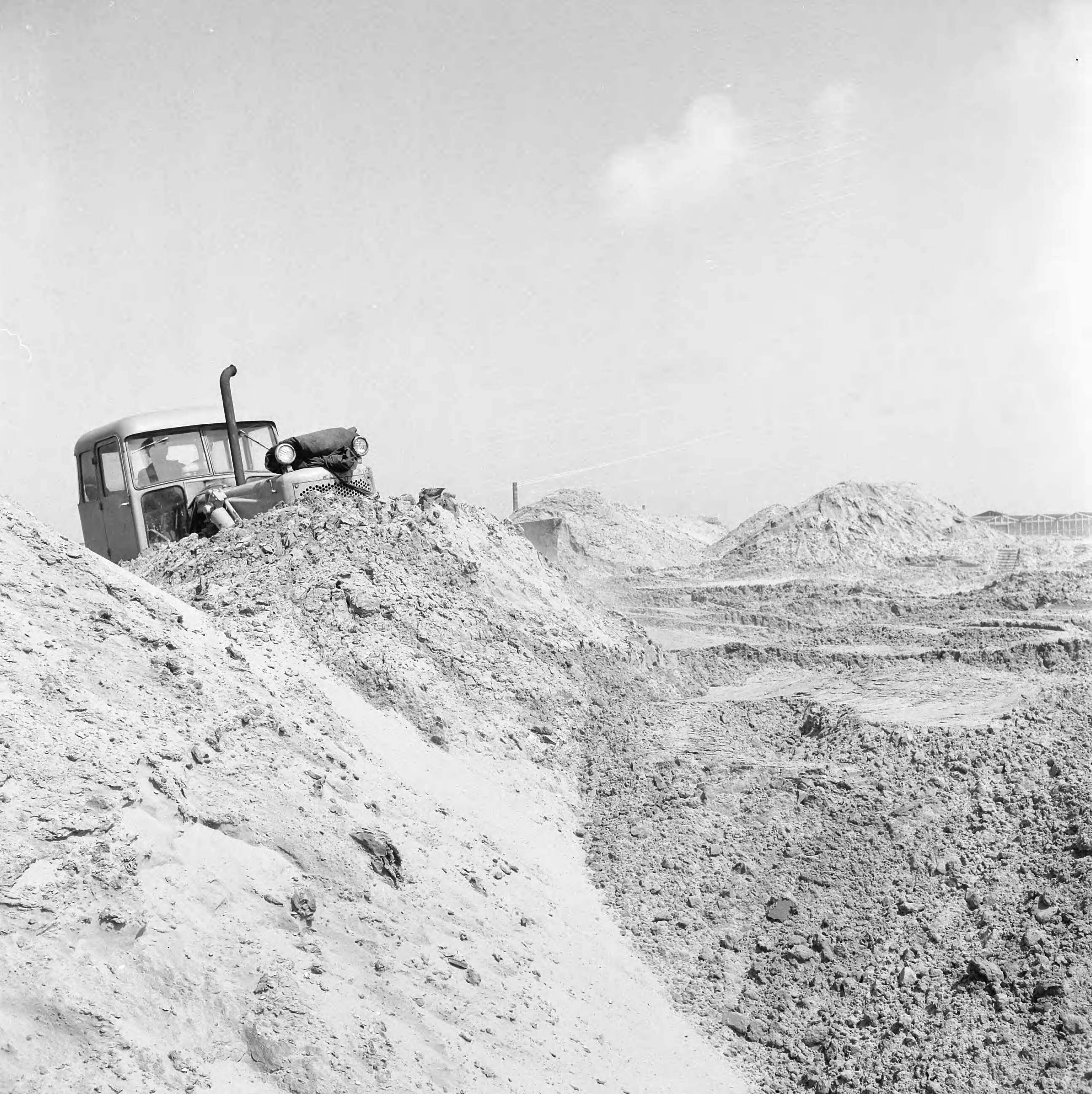 Fotocollectie Nederlandse Heidemaatschappij — Object gemeente 's-Gravenhage. Kerketuinen. Het na te spitten achtergebleven maanlandschap wordt d.m.v een bulldozer geëgaliseerd — Foto: Wüllschleger, [...] / Heidemij. Licentie: Set B: Rechtenvrij / Publiek Domein. Bron: Nationaal Archief. http://hdl.handle.net/10648/ae5e7a5c-d0b4-102d-bcf8-003048976d84