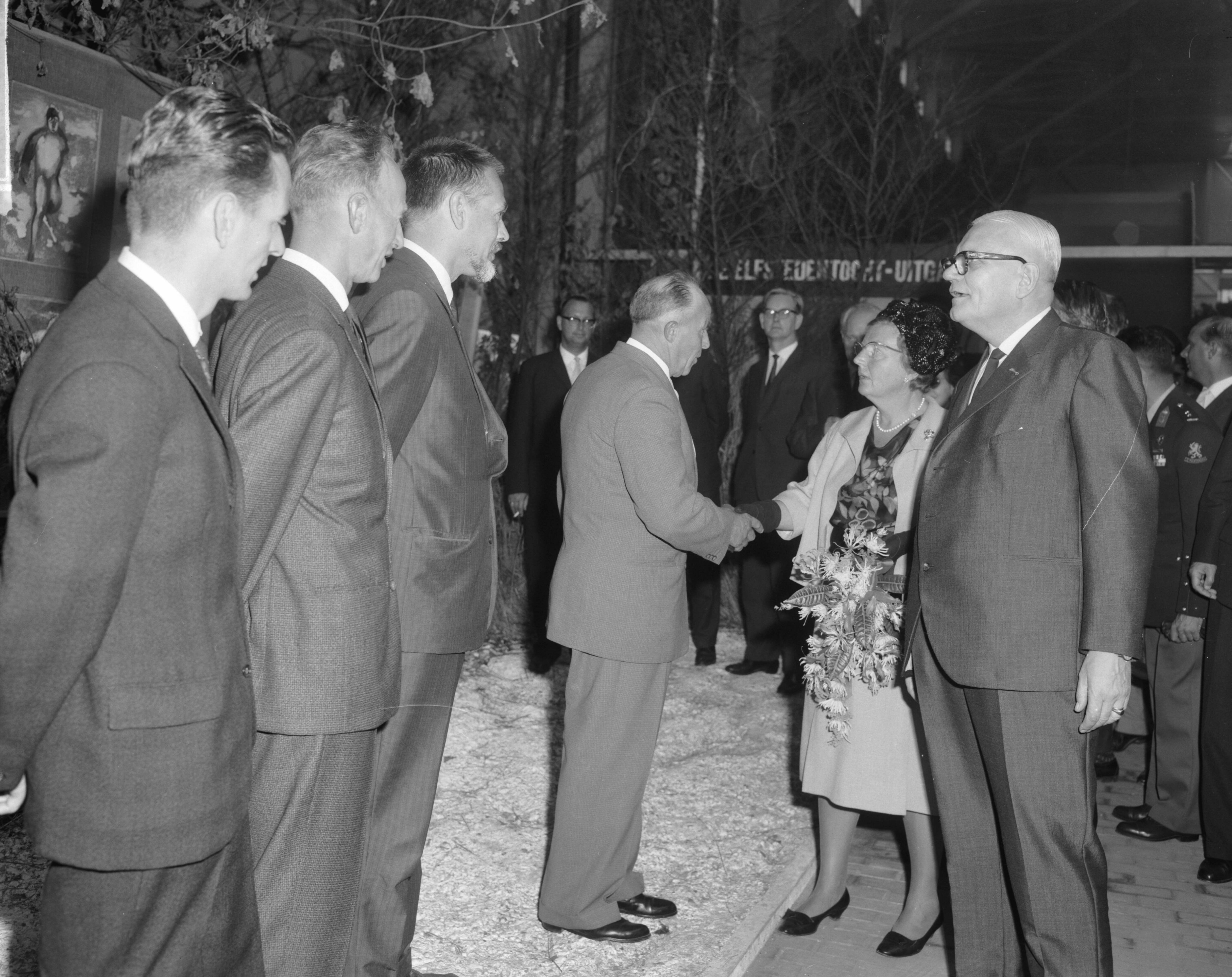 Fotocollectie Anefo — Koningin Juliana bracht een bezoek aan de tentoonstelling "Frisiana" te Leeuwarden. De koningin wordt voorgesteld aan een drietal Elfstedenwinnaars vlnr. Jeen van den Berg (winnaar 1954), Sipke Castelein (gedeeld winnaar 1933), tekenaar Kees Bantzinger wiens Elfstedentekeningen worden geëxposeerd, en Auka Adema (gedeeld winnaar 1940, winnaar 1941), die de hand van de koningin schudt. Rechts de voorzitter van de Vereniging De Friese Elf Steden J.L. Hoogland — Foto: Bilsen, Joop van / Anefo. Licentie: Set B: Rechtenvrij / Publiek Domein. Bron: Nationaal Archief. http://hdl.handle.net/10648/aa45e7a2-d0b4-102d-bcf8-003048976d84