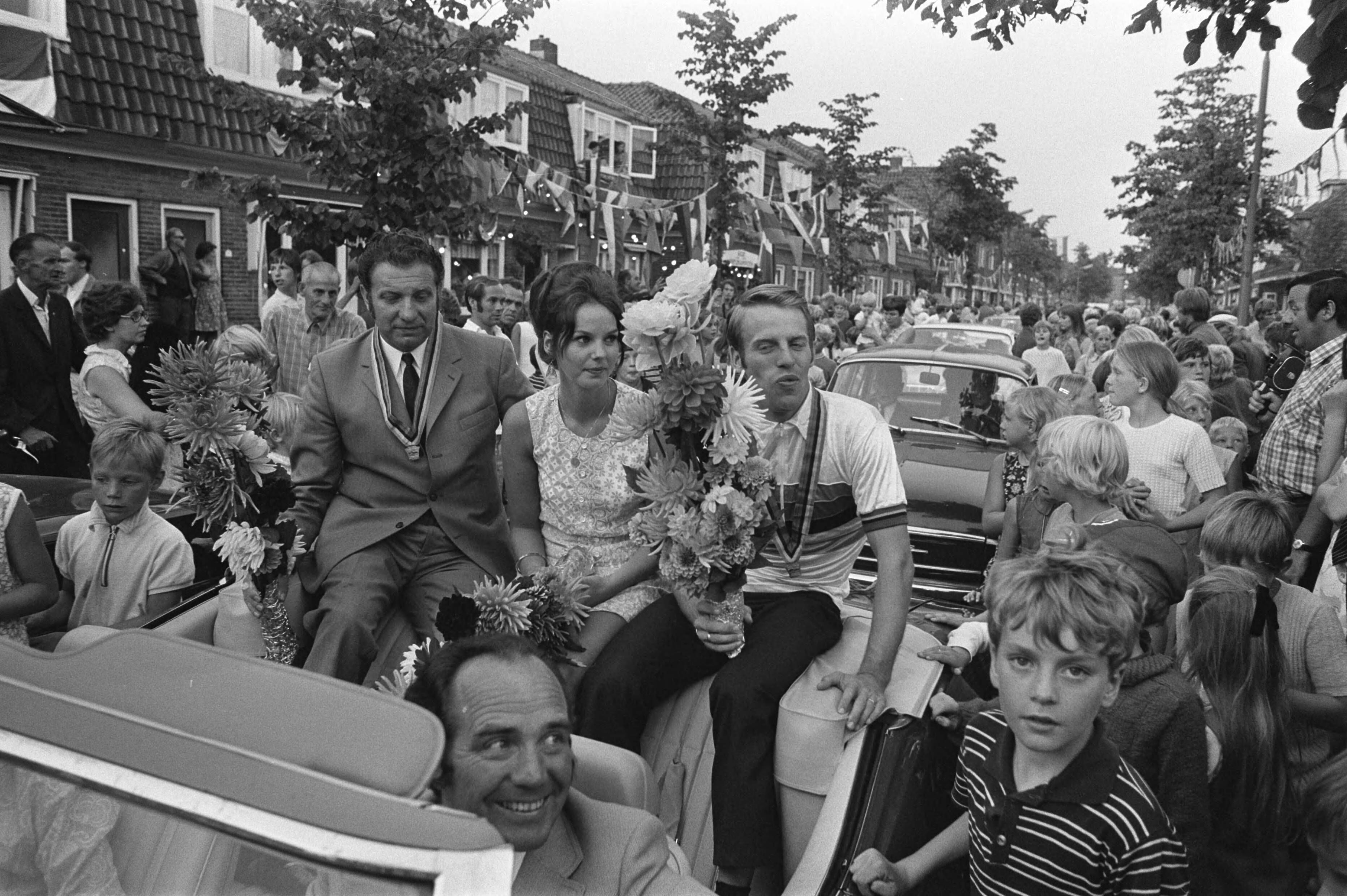 Fotocollectie Anefo — Wielrenner Cees Stam wordt gehuldigd in Koog aan de Zaan ; gangmaker Stakenburg en Stam en echtgenote in auto in het dorp — Foto: Verhoeff, Bert / Anefo. Licentie: Set B: Rechtenvrij / Publiek Domein. Bron: Nationaal Archief. http://hdl.handle.net/10648/ab9f7b54-d0b4-102d-bcf8-003048976d84