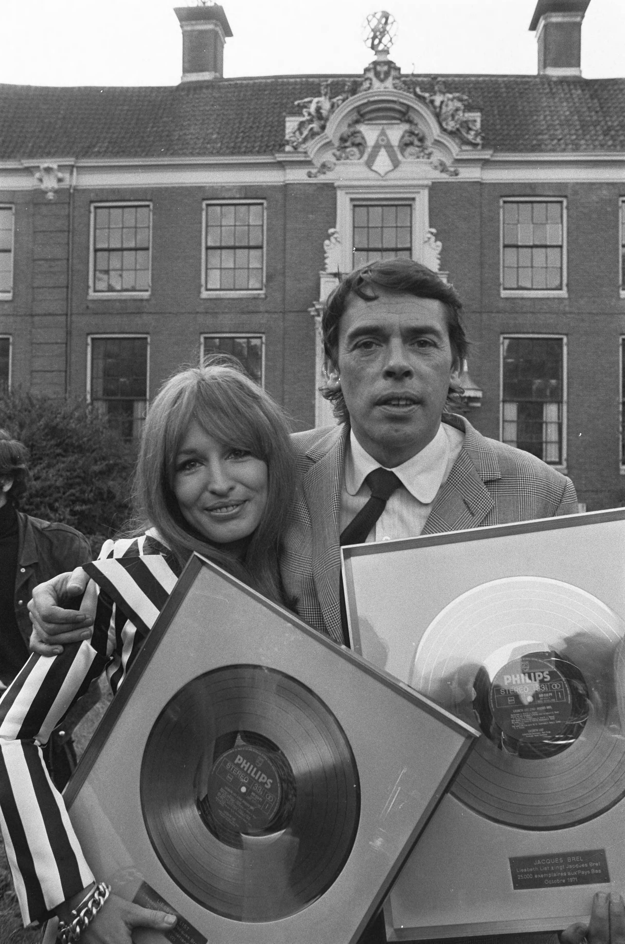 Fotocollectie Anefo — Liesbeth List krijgt gouden LP voor "Liesbeth List zingt J. Brel" op kasteel Groeneveld te Baarn: Liesbeth List en Jacques Brel — Foto: Mieremet, Rob / Anefo. Licentie: Set B: Rechtenvrij / Publiek Domein. Bron: Nationaal Archief. http://hdl.handle.net/10648/abd4a644-d0b4-102d-bcf8-003048976d84