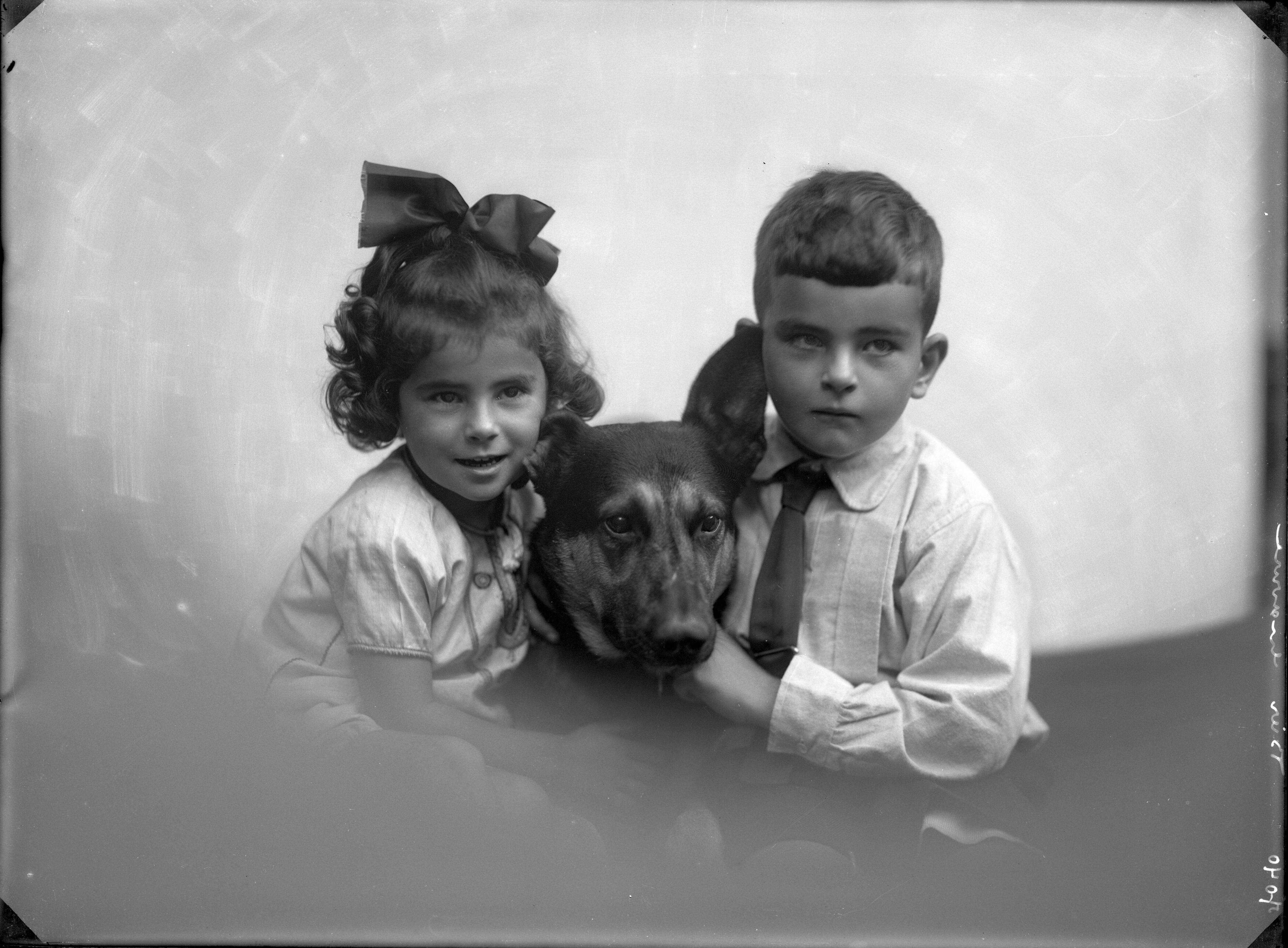 Portretten — Studio-opnames. Portret van een jongetje en een meisje met hun herdershond tussen hen in. Haarlem, Nederland. 1918-1930. 7040 Bier gravure — Foto: Berg, Th.C.J. van den / Spaarnestad Photo (05887). Licentie: Set B: Rechtenvrij / Publiek Domein. Bron: Nationaal Archief. http://hdl.handle.net/10648/35429da7-c7f4-a382-e063-6df0900a6686