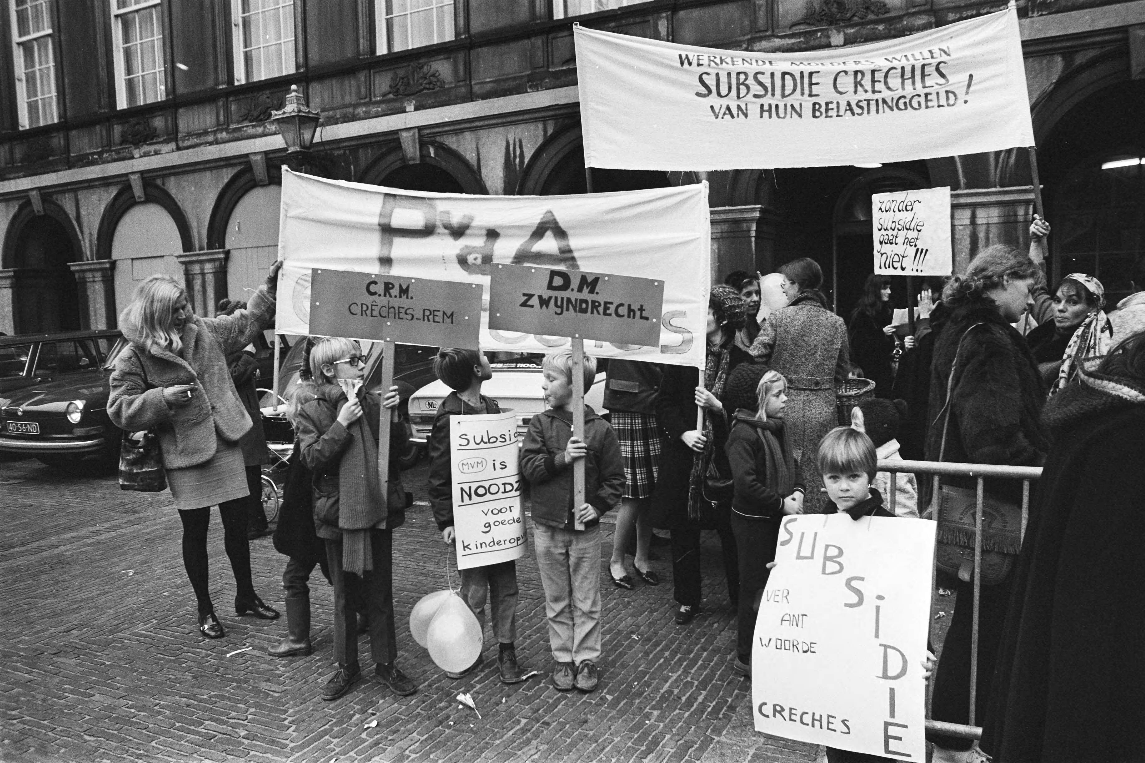 Fotocollectie Anefo — Demonstratie "Dolle Mina" tegen uitblijven van creches op Binnenhof, Den Haag ; Dolle Minas met kinderen en borden op Binnenhof — Foto: Mieremet, Rob / Anefo. Licentie: Set B: Rechtenvrij / Publiek Domein. Bron: Nationaal Archief. http://hdl.handle.net/10648/abaa5204-d0b4-102d-bcf8-003048976d84