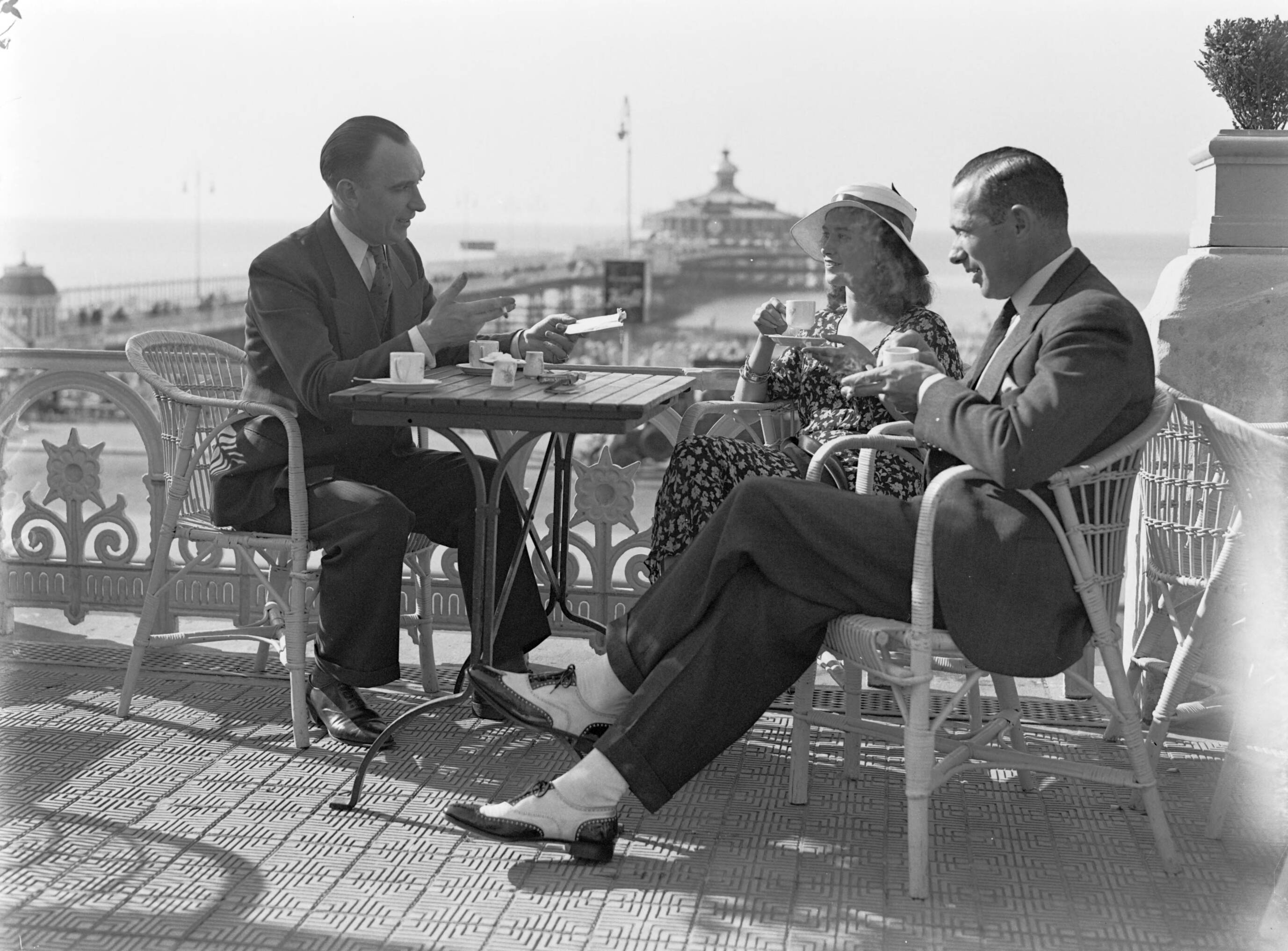 Scheveningen. — Een vrouw (mevrouw Ott?) en twee mannen op een terras aan de boulevard in Scheveningen — Foto: Poll, Willem van de. Licentie: Set B: Rechtenvrij / Publiek Domein. Bron: Nationaal Archief. http://hdl.handle.net/10648/ae9ab094-d0b4-102d-bcf8-003048976d84