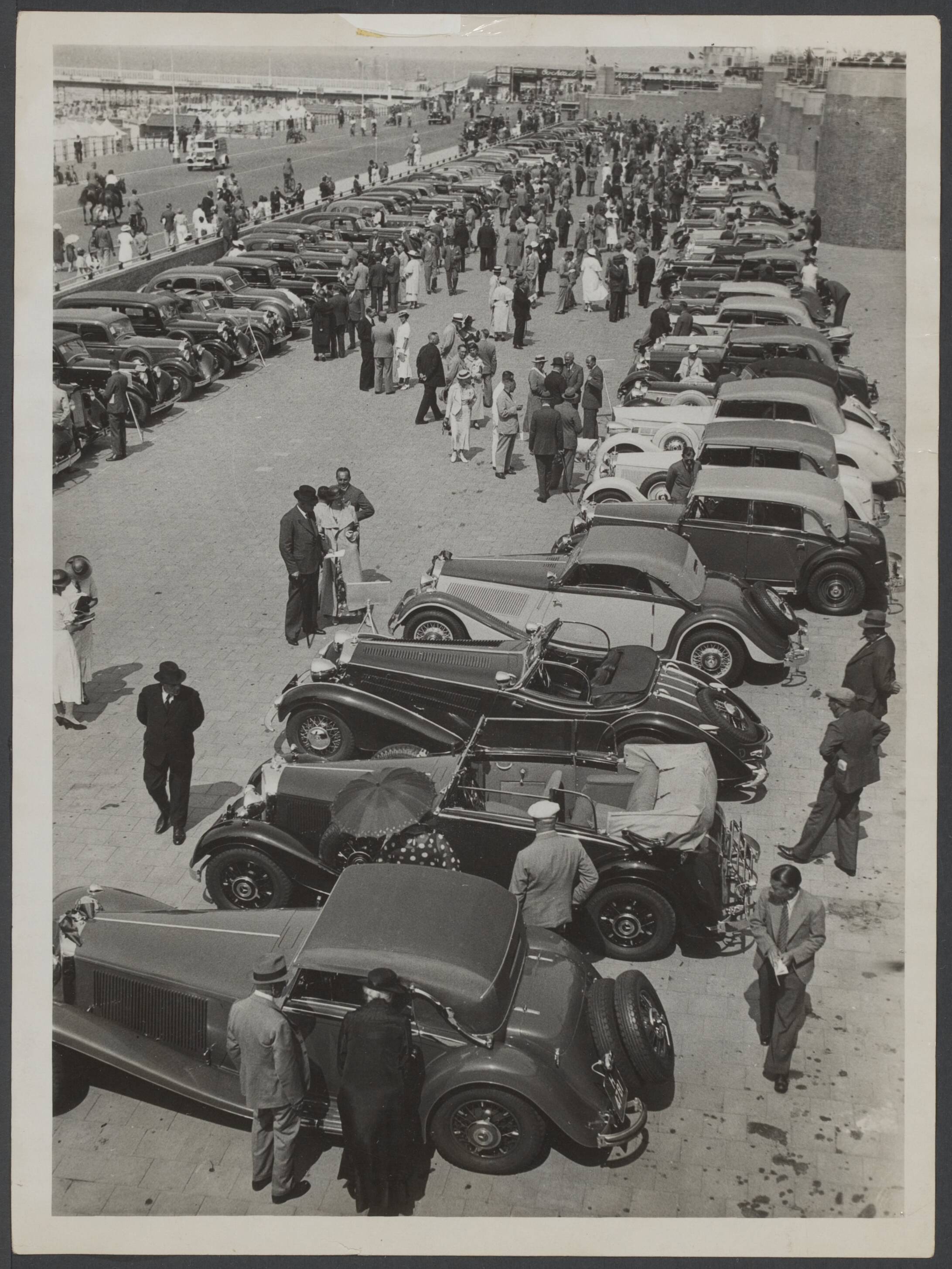 Autotentoonstellingen tot 1965, concours d'elegance, mode en auto — [auto's staan opgesteld op de boulevard van Scheveningen. Publiek bekijkt de auto's] — Foto: N.V. Vereenigde Fotobureaux. Licentie: Set B: Rechtenvrij / Publiek Domein. Bron: Nationaal Archief. http://hdl.handle.net/10648/431850d9-2895-220c-2f0f-174286c48ea4