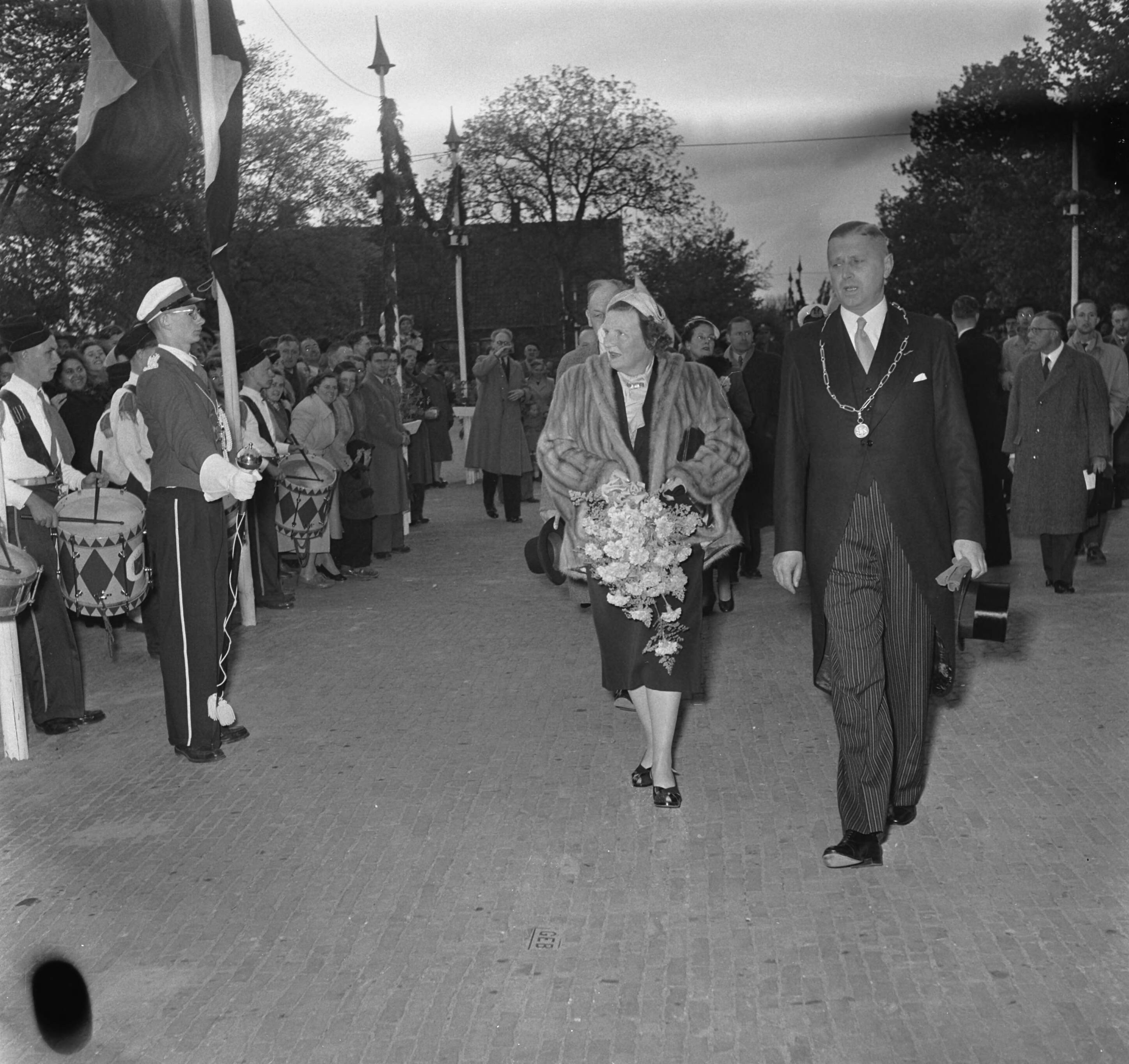 Koninklijk bezoek aan 15 gemeentes in Zuid-Holland (Rijnstreek en Merengebied) — Koningin Juliana bezoekt Bodegraven. Zij loopt met burgemeester J.J. Croles langs een muziekkorps — Foto: Noske, J.D. / Anefo. Licentie: Set B: Rechtenvrij / Publiek Domein. Bron: Nationaal Archief. http://hdl.handle.net/10648/a9223ae2-d0b4-102d-bcf8-003048976d84