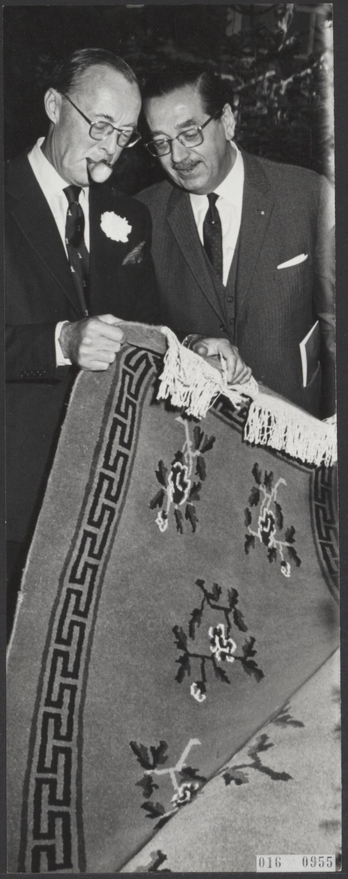 Fotocollectie Elsevier Binnenland — Prins Bernhard heeft de nieuwe studio van de N.T.S. in gebruik gesteld. Bij de opening overhandigde hij de voorzitter van de Raad van Beheer van de N.T.S. , E.A. Schüttenhelm, een geknoopt karpet — Foto: Kroon, Ron / Anefo. Licentie: Set B: Rechtenvrij / Publiek Domein. Bron: Nationaal Archief. http://hdl.handle.net/10648/adbaf328-d0b4-102d-bcf8-003048976d84