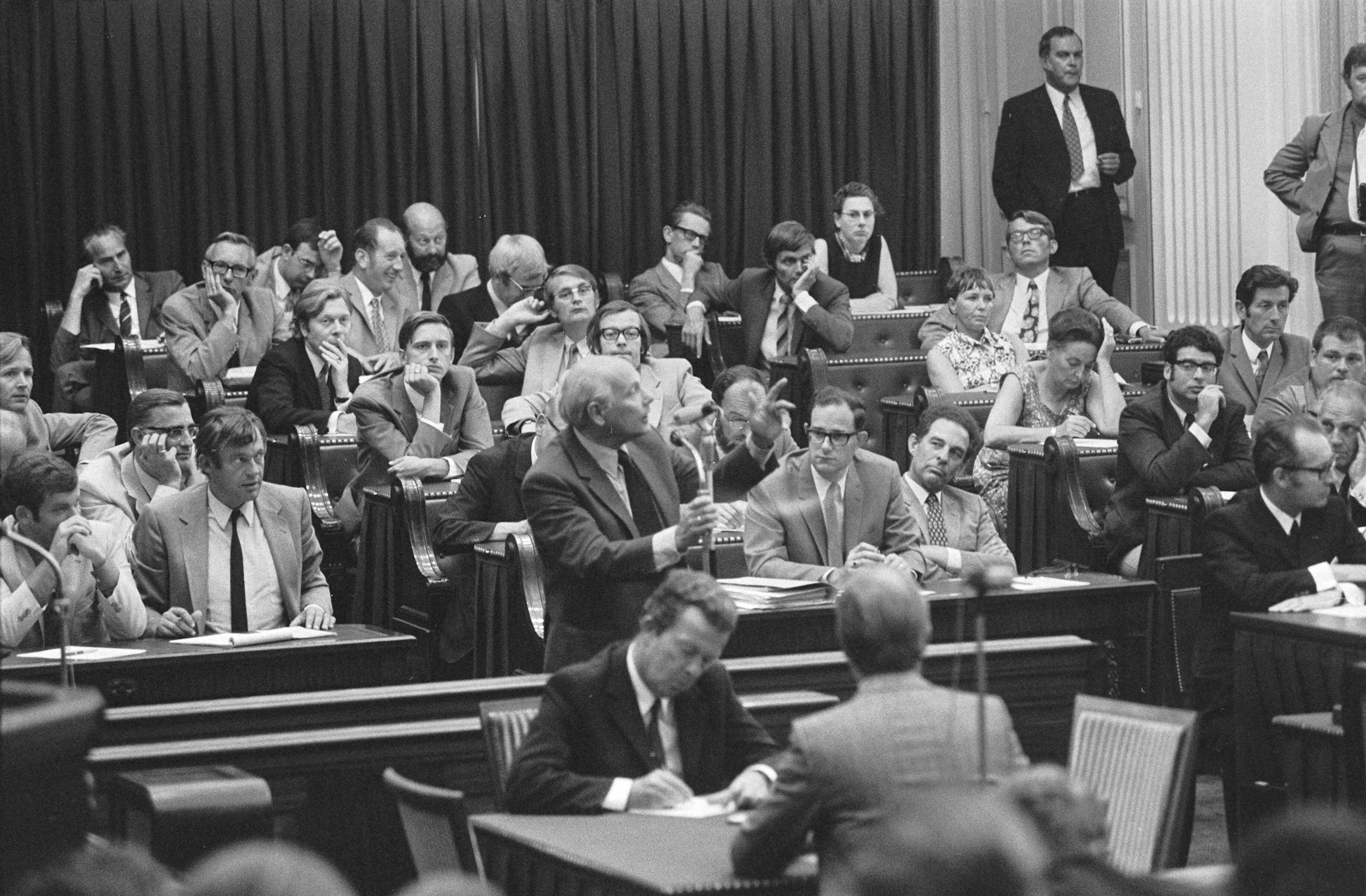 Fotocollectie Anefo — Regeringsverklaring van nieuwe kabinet in Tweede Kamer , nr. 33, 34 Den Uyl , interrumpeert, achter hem rechts de fractie PvdA, links gedeelte fractie D66 / — Foto: Mieremet, Rob / Anefo. Licentie: Set B: Rechtenvrij / Publiek Domein. Bron: Nationaal Archief. http://hdl.handle.net/10648/abc8b8b6-d0b4-102d-bcf8-003048976d84