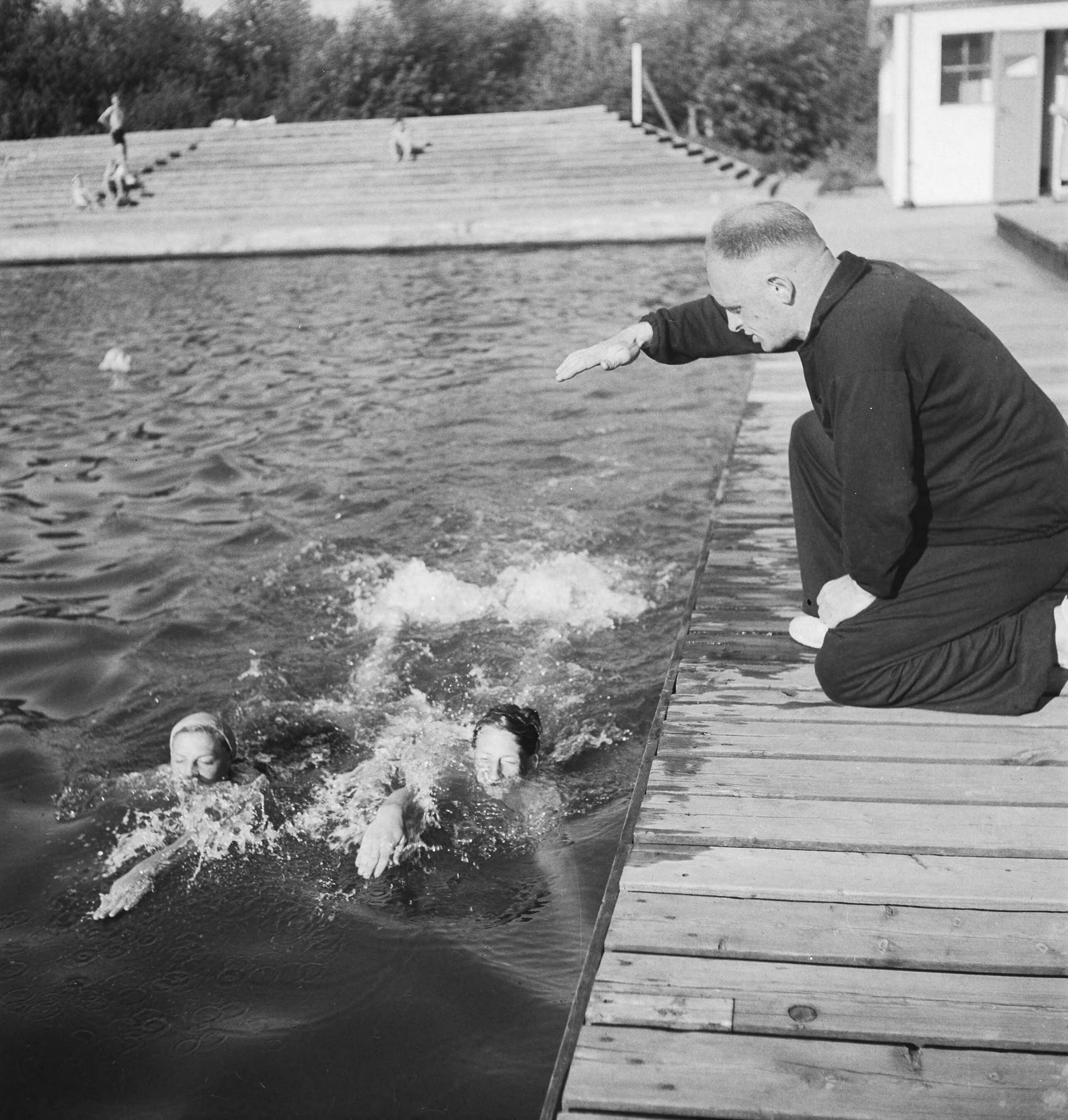 Zwemtraining o.l.v. trainer Jan Stender — Trainer Jan Stender geeft aanwijzingen. — Foto: Merk, Ben / Anefo. Licentie: Set B: Rechtenvrij / Publiek Domein. Bron: Nationaal Archief. http://hdl.handle.net/10648/ad754a3a-d0b4-102d-bcf8-003048976d84