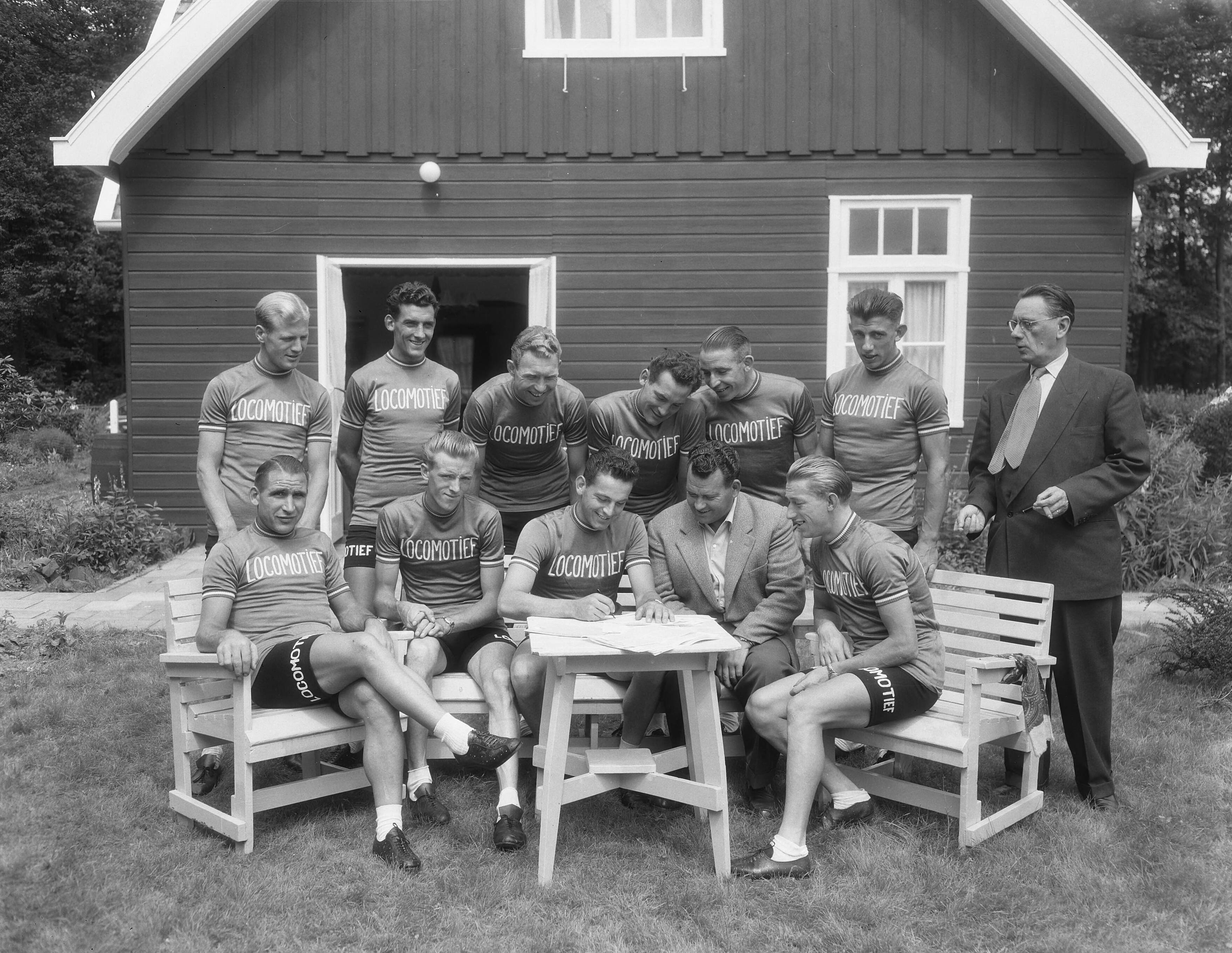 Ondertekening van contracten van Tour de France ploeg ten huize van Cees Pellenaars te Breda — Ondertekening van contracten van Tour de France ploeg ten huize van Cees Pellenaars te Breda, groep [staand vlnr. Adri Suijkerbuijk, Gerrit Voorting, Henk Faanhof, Hein van Breenen, Nico van Est, Thijs Roks, Zittend vlnr. Wim van Est, Jan Nolten, Jules Maenen, Cees Pellenaars en Wout Wagtmans — Foto: Duinen, G.W. van / Anefo. Licentie: Set B: Rechtenvrij / Publiek Domein. Bron: Nationaal Archief. http://hdl.handle.net/10648/a924ac46-d0b4-102d-bcf8-003048976d84