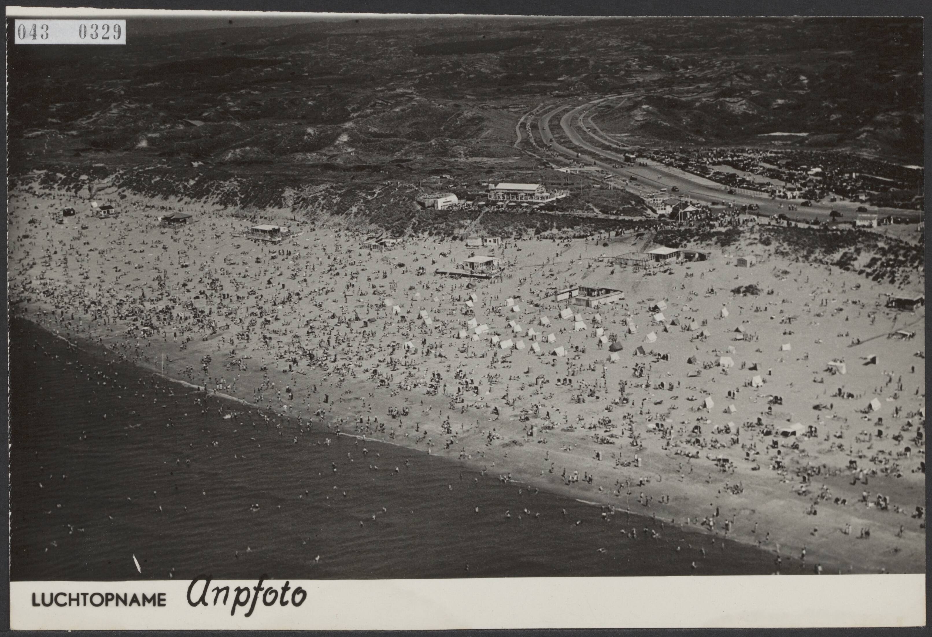 Fotocollectie Elsevier Binnenland — Luchtopname. Drukte op het Bloemendaalse strand. In het midden op de achtergrond de Zeeweg met een dichte rij fietsers richting strand — Foto: ANP / RVD of rechtenvrij. Licentie: Set B: Rechtenvrij / Publiek Domein. Bron: Nationaal Archief. http://hdl.handle.net/10648/adf8b19a-d0b4-102d-bcf8-003048976d84