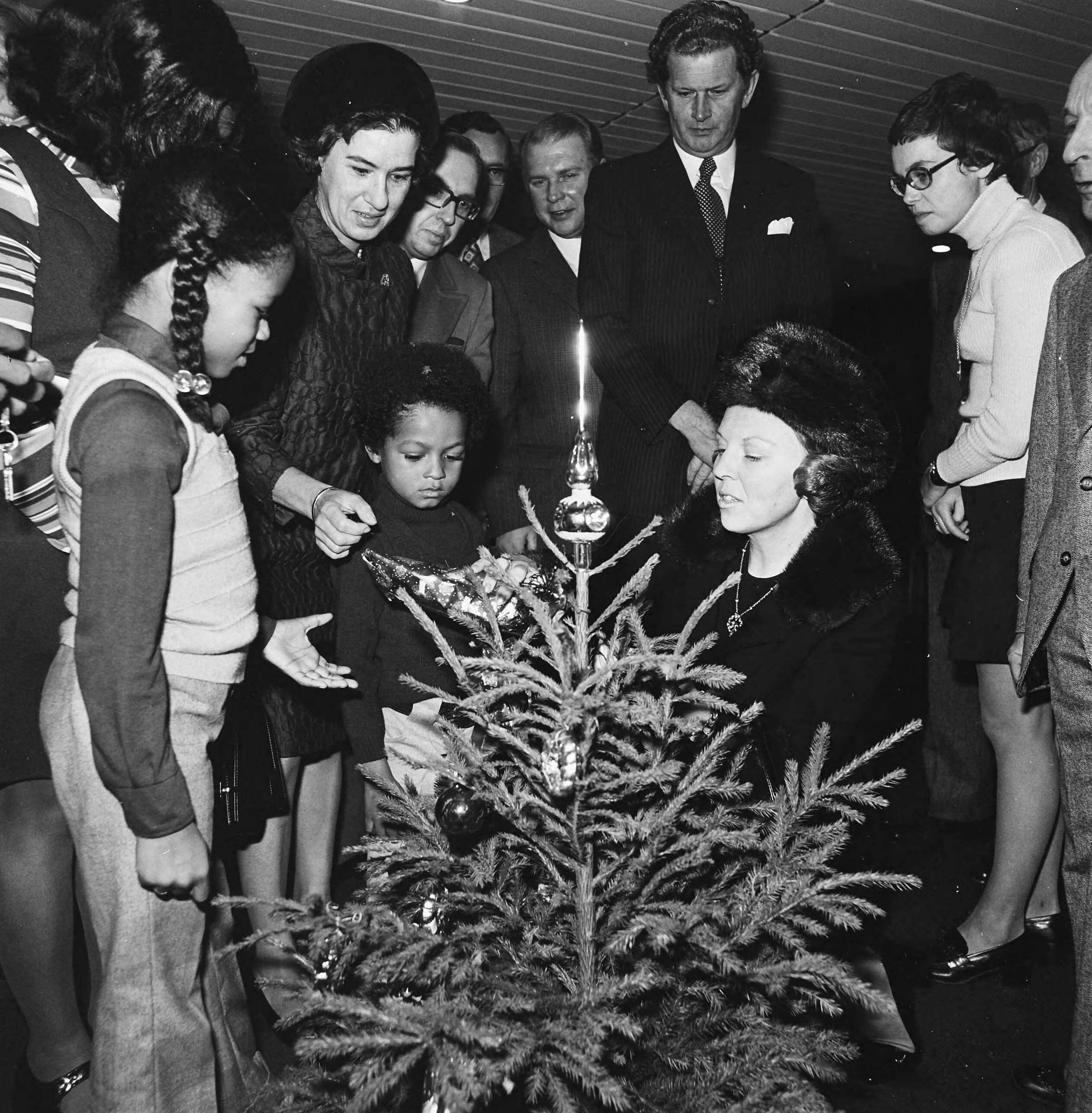 Prinses Beatrix overhandigt de sleutel van de dertigste burgerzinwoning in het stadhuis van Den Haag — De prinses met kinderen en genodigden bij een kerstboom — Foto: Mieremet, Rob / Anefo. Licentie: Set B: Rechtenvrij / Publiek Domein. Bron: Nationaal Archief. http://hdl.handle.net/10648/ac3ed424-d0b4-102d-bcf8-003048976d84
