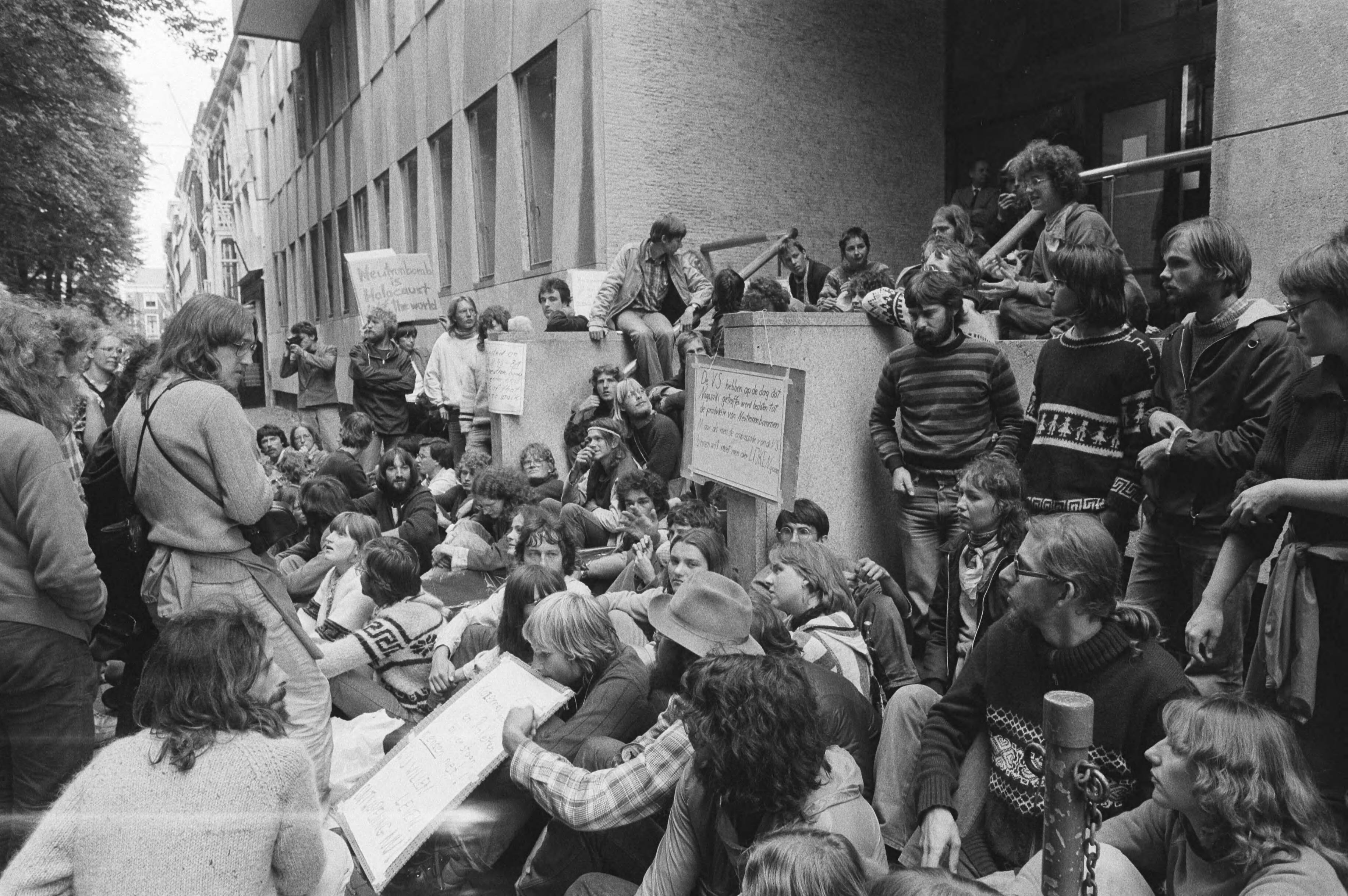 Demonstratie voor de VS-ambassade in Den Haag in verband met de productie van de neutronenbom — Demonstranten voor de ambassade — Foto: Dijk, Hans van / Anefo. Licentie: Set B: Rechtenvrij / Publiek Domein. Bron: Nationaal Archief. http://hdl.handle.net/10648/ad014d10-d0b4-102d-bcf8-003048976d84