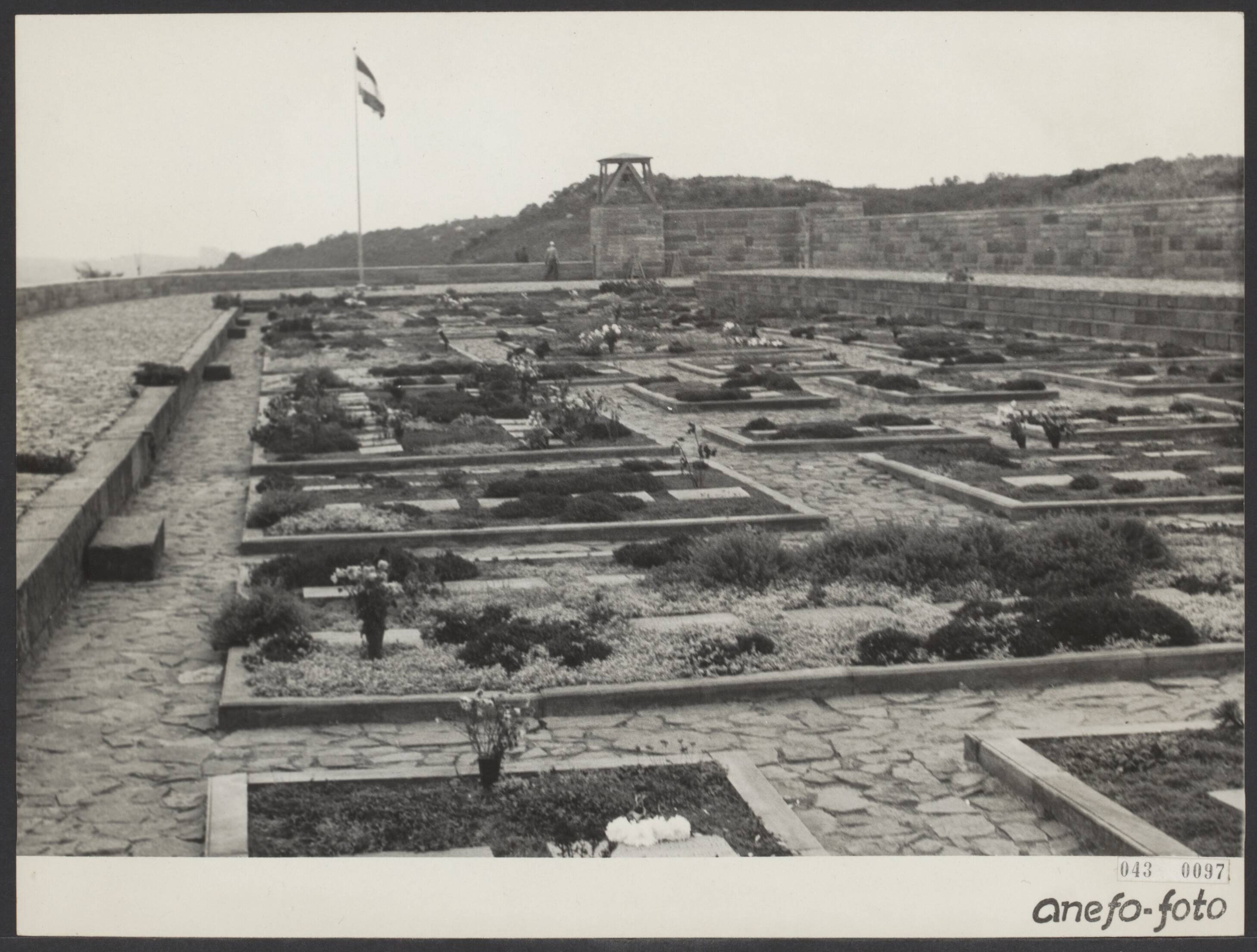 Fotocollectie Elsevier Binnenland — De erebegraafplaats te Bloemendaal is nu bijna geheel voltooid en in de staat gebracht zoals het oorspronkelijk het plan is geweest. Alle graven zijn van een stenen rand voorzien, terwijl om het geheel een muur is geplaatst, waardoor de begraafplaats beter bestemd is tegen verstuivingen in de duinen — Foto: Fotograaf Onbekend / Anefo. Licentie: Set B: Rechtenvrij / Publiek Domein. Bron: Nationaal Archief. http://hdl.handle.net/10648/adf8504c-d0b4-102d-bcf8-003048976d84