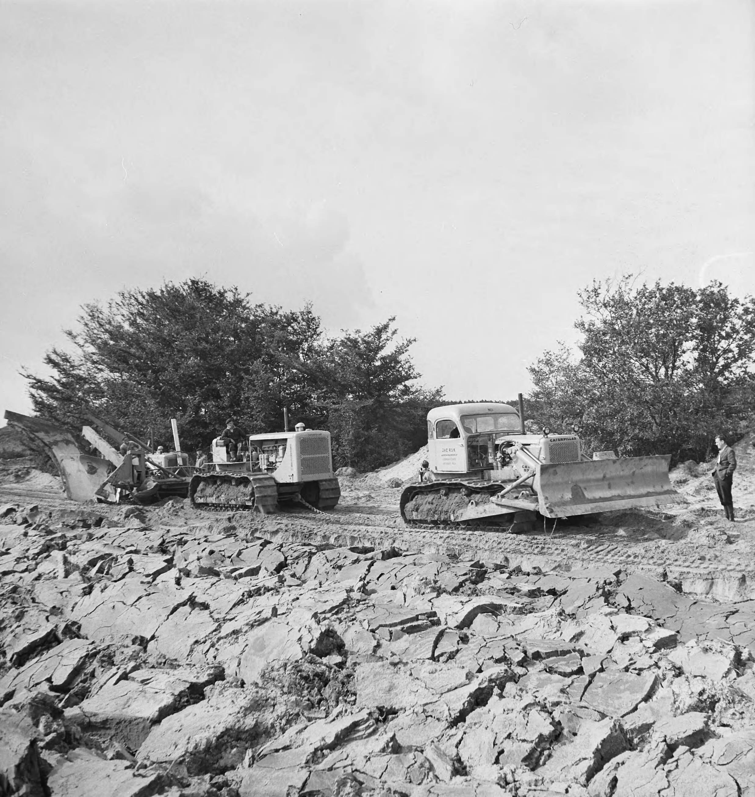Fotocollectie Nederlandse Heidemaatschappij — Diepploegen acter de duinstrook (Vrouwenpolders - Walcheren). Totale combinatie; voorop D7, daarna D8, vervoglens D6 Caterpillar trekker, de laatste met aangebouwde ploeg — Foto: Fotograaf Onbekend / Heidemij. Licentie: Set B: Rechtenvrij / Publiek Domein. Bron: Nationaal Archief. http://hdl.handle.net/10648/ae5d6298-d0b4-102d-bcf8-003048976d84